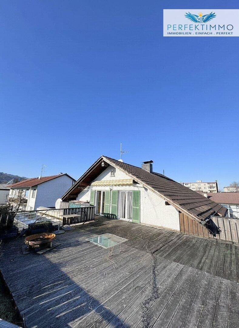 Große Dachterrasse mit Holzboden und Blick auf die Umgebung.