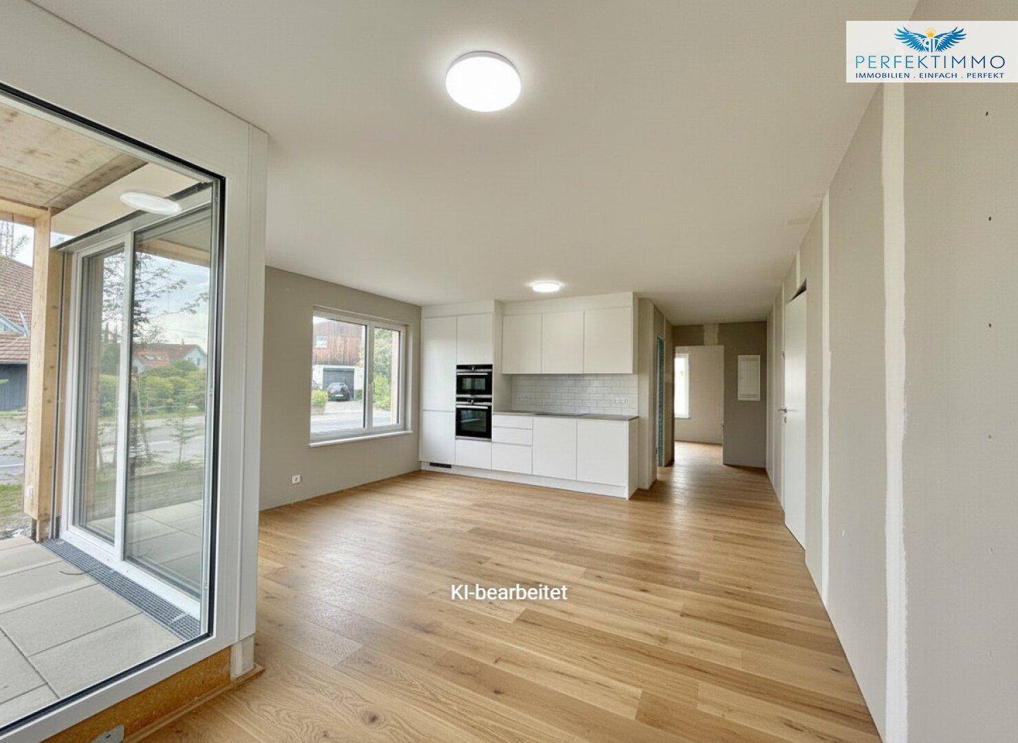 Offener Wohnbereich mit integrierter, moderner Einbauküche und Zugang zur Terrasse.