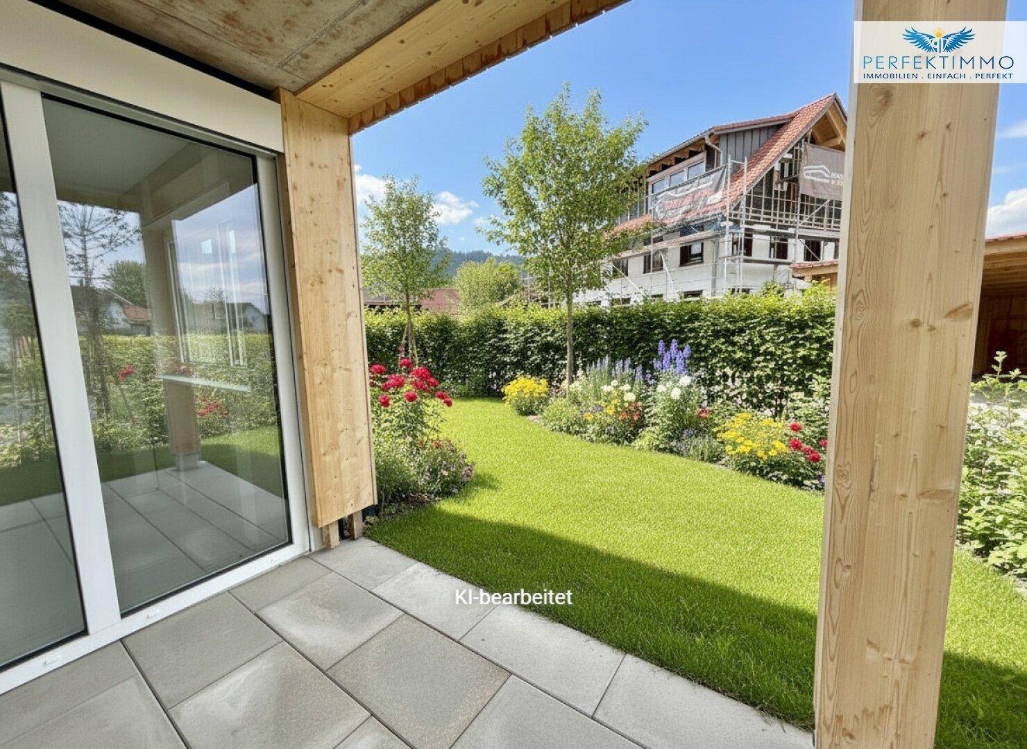 Gepflasterte Terrasse mit Zugang zu einem kleinen, gepflegten Garten und Hecke.