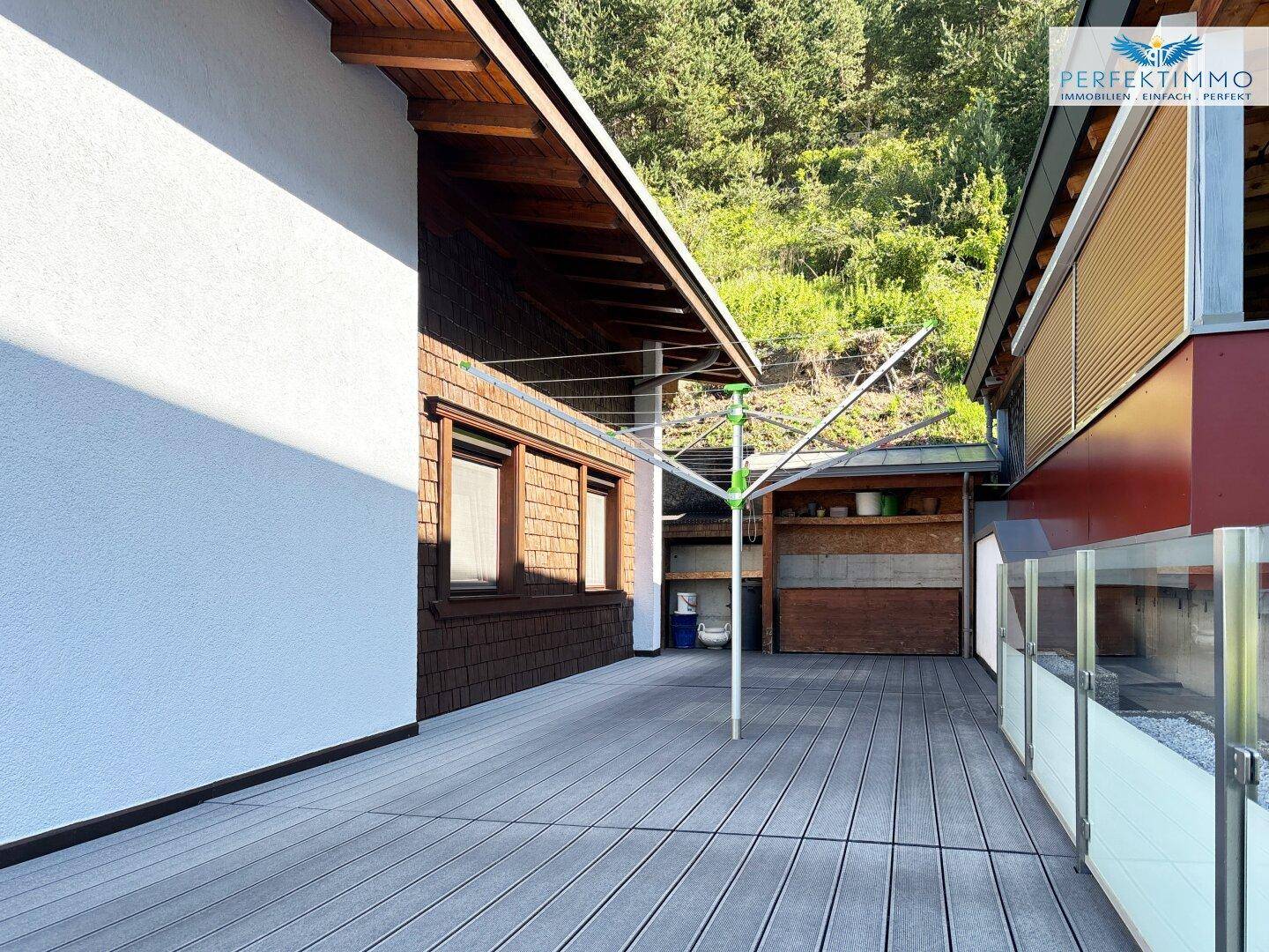 Geräumige Terrasse mit Wäscheständer und Blick auf die grüne Umgebung.