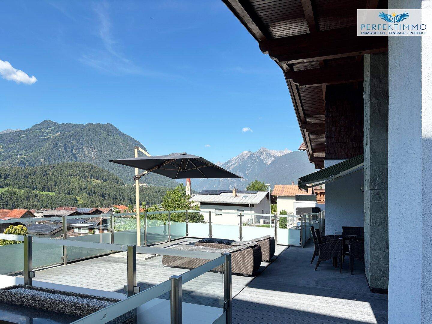 Weitläufige Terrasse mit Sitzgelegenheiten und Panoramablick auf die umliegende Bergwelt.