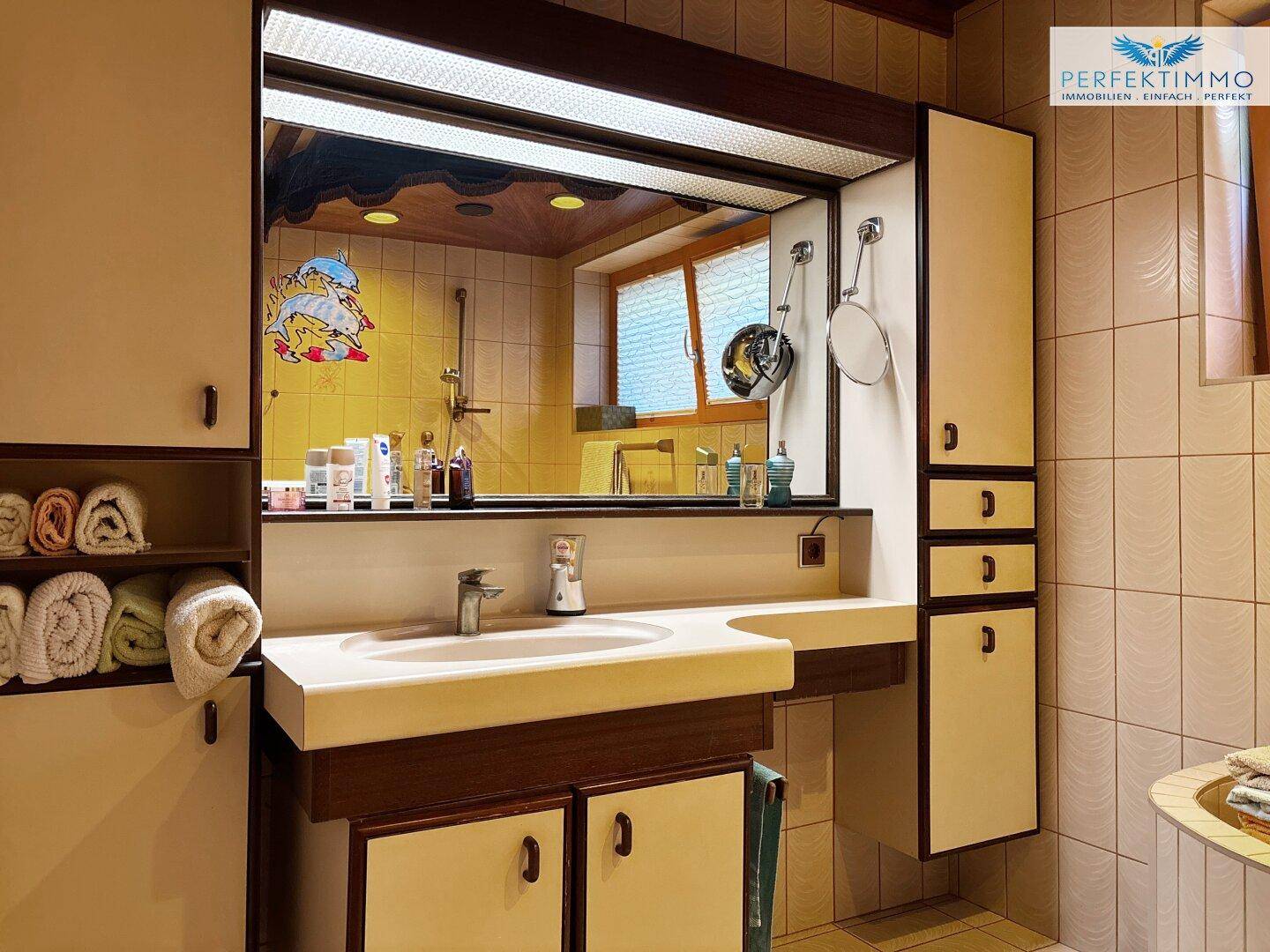 Badezimmer mit Einzelwaschbecken, Spiegelschrank und Fliesenboden.