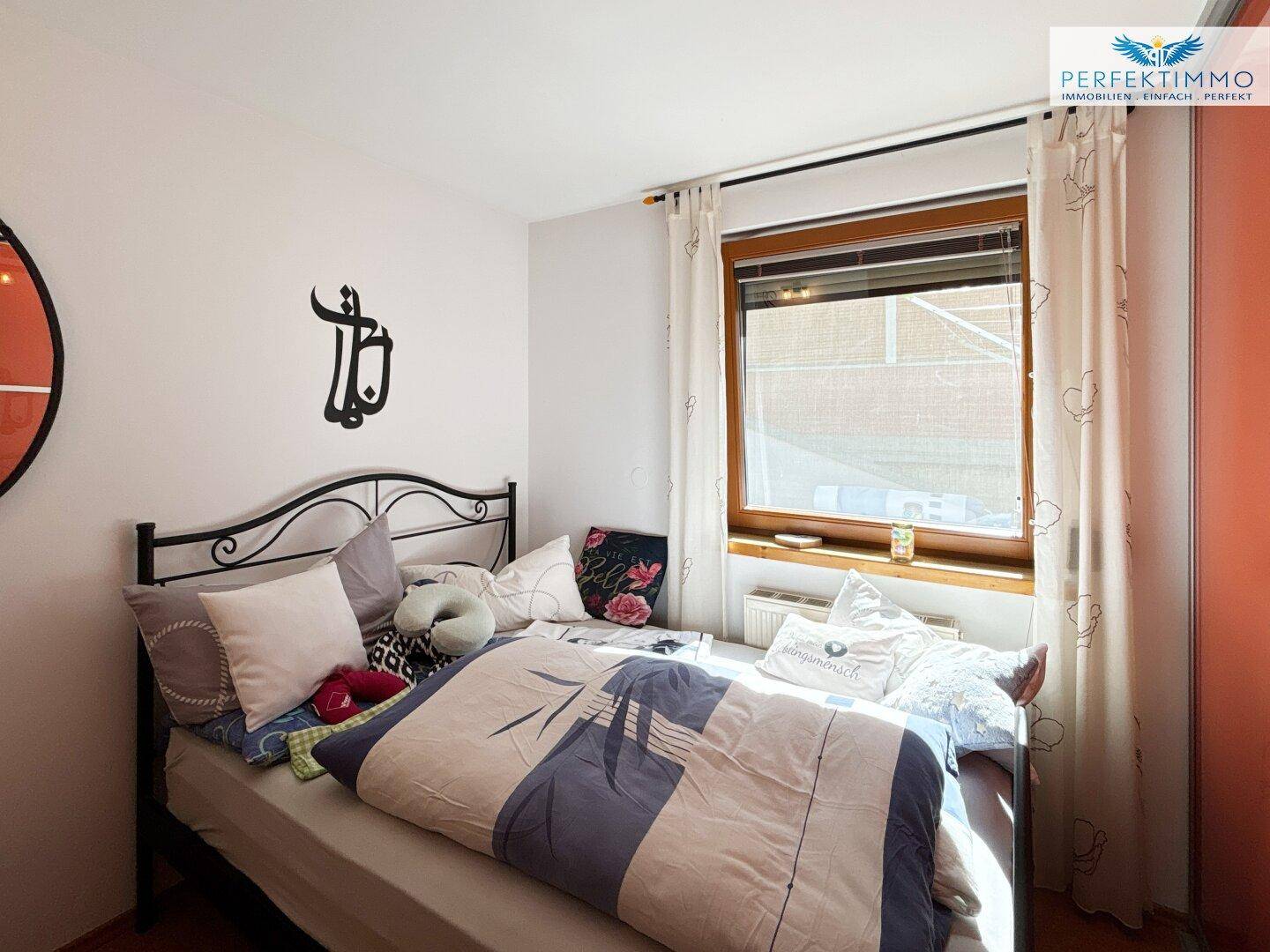 Gemütliches Schlafzimmer mit Doppelbett und Fenster, das für eine helle Atmosphäre sorgt.