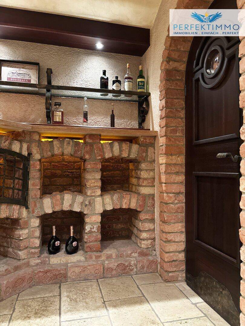 Detailansicht des Weinkellers mit Ziegelregalen und einer dunklen Holztür, die den Charme unterstreicht.
