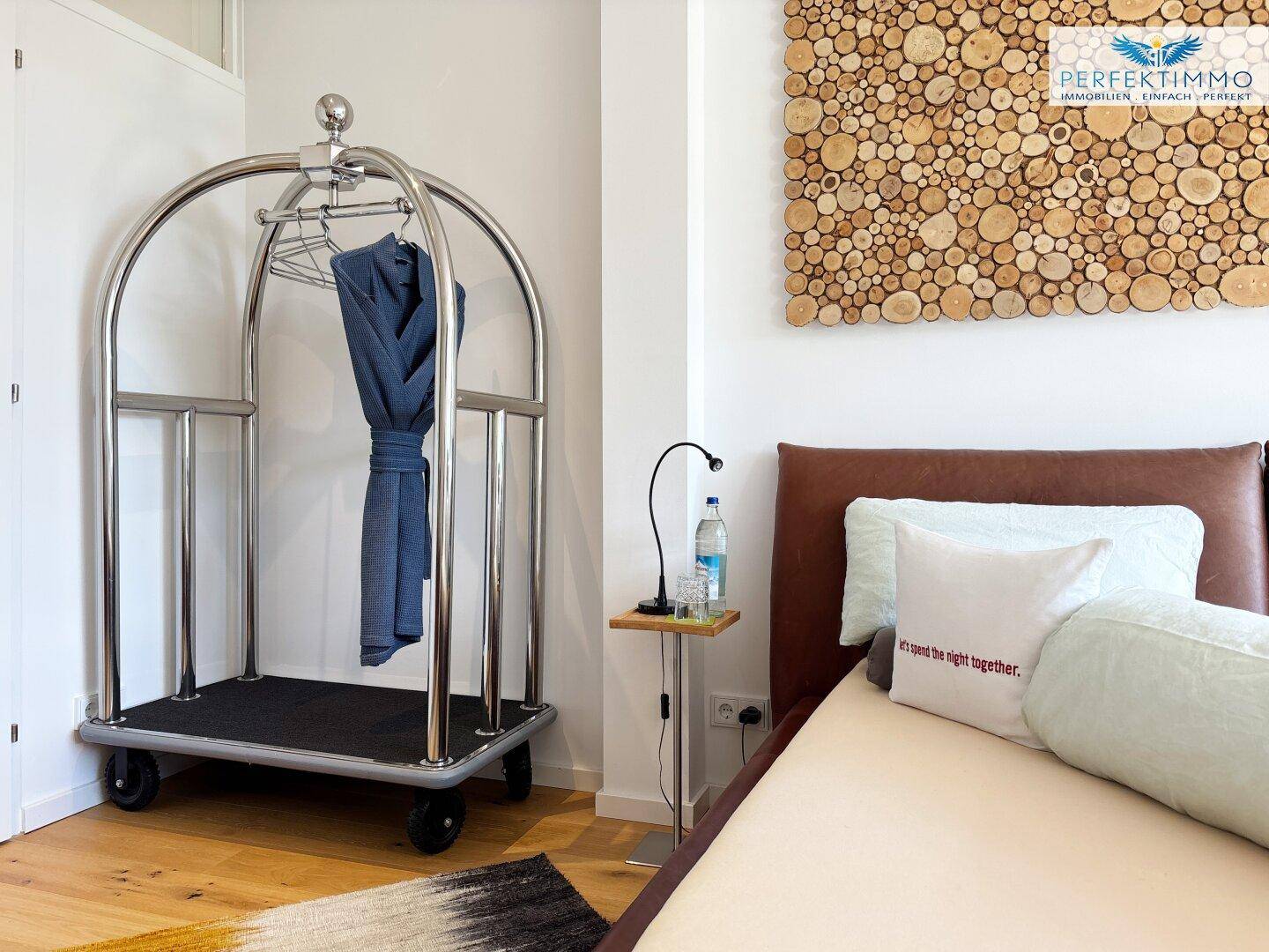 Detailansicht des Bettes und eines Gepäckwagens in einem modern eingerichteten Schlafzimmer.