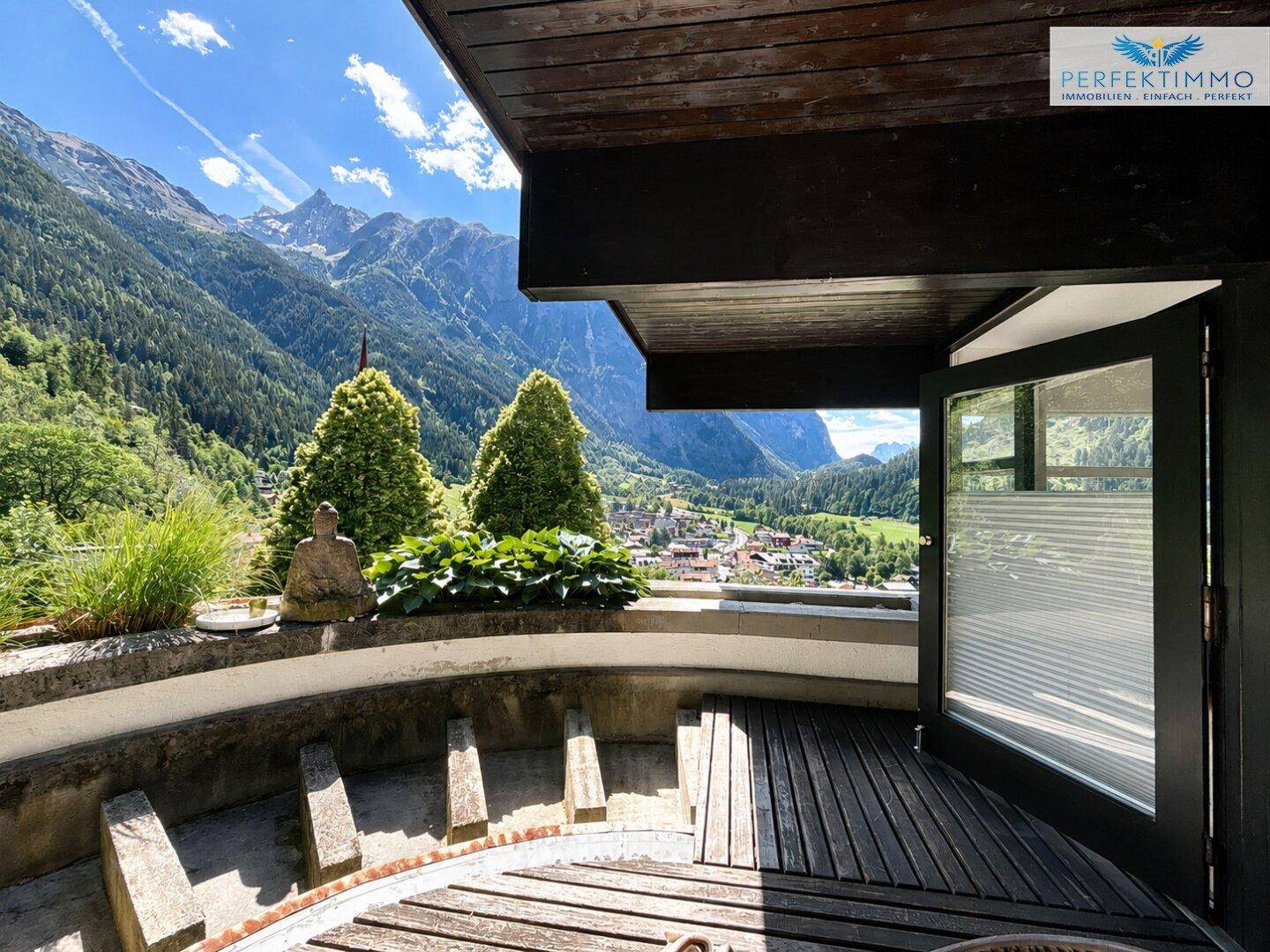Terrasse mit atemberaubendem Bergblick, Holzboden und dekorativen Pflanzen.