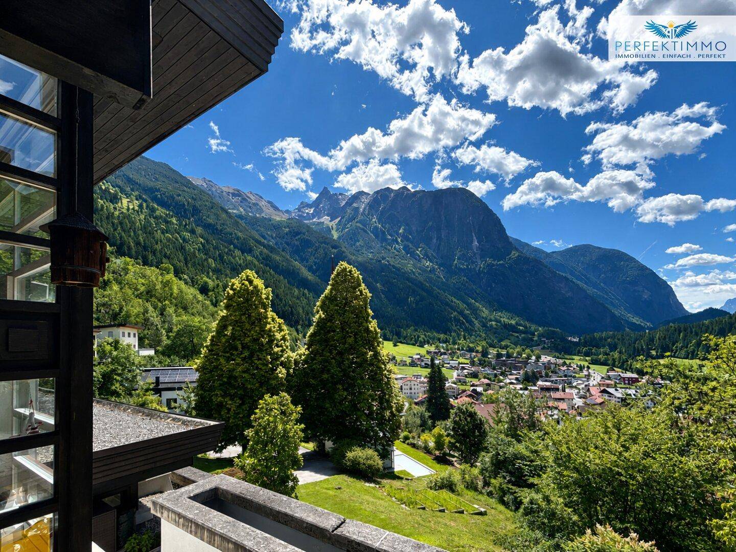 Malerischer Ausblick auf die Bergwelt und ein idyllisches Tal mit Dorf.