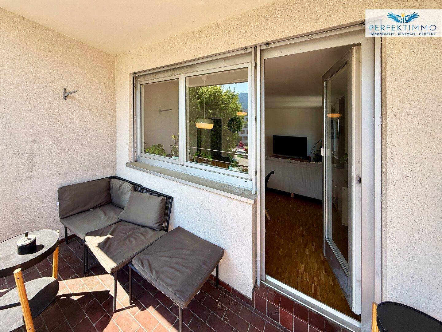Möblierter Balkon mit Sitzgelegenheiten und Zugang zum Innenbereich der Wohnung.