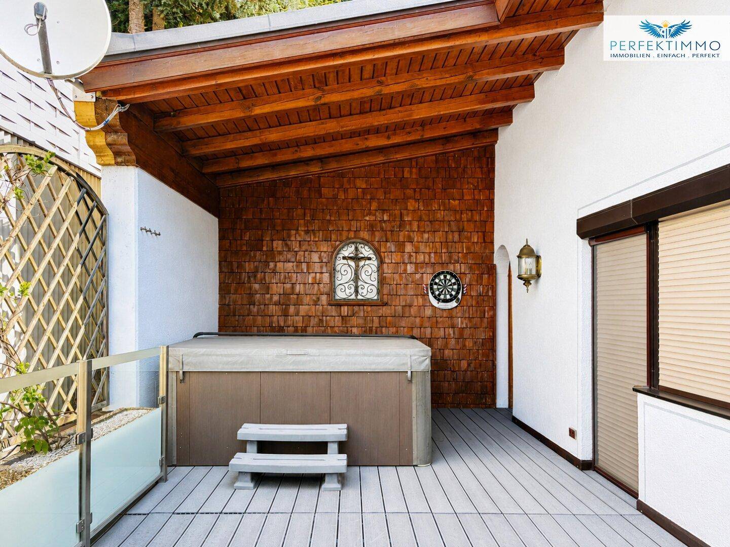 Überdachte Terrasse mit Whirlpool, Holzverkleidung und Sichtschutz, perfekt für private Wellnessmomente.