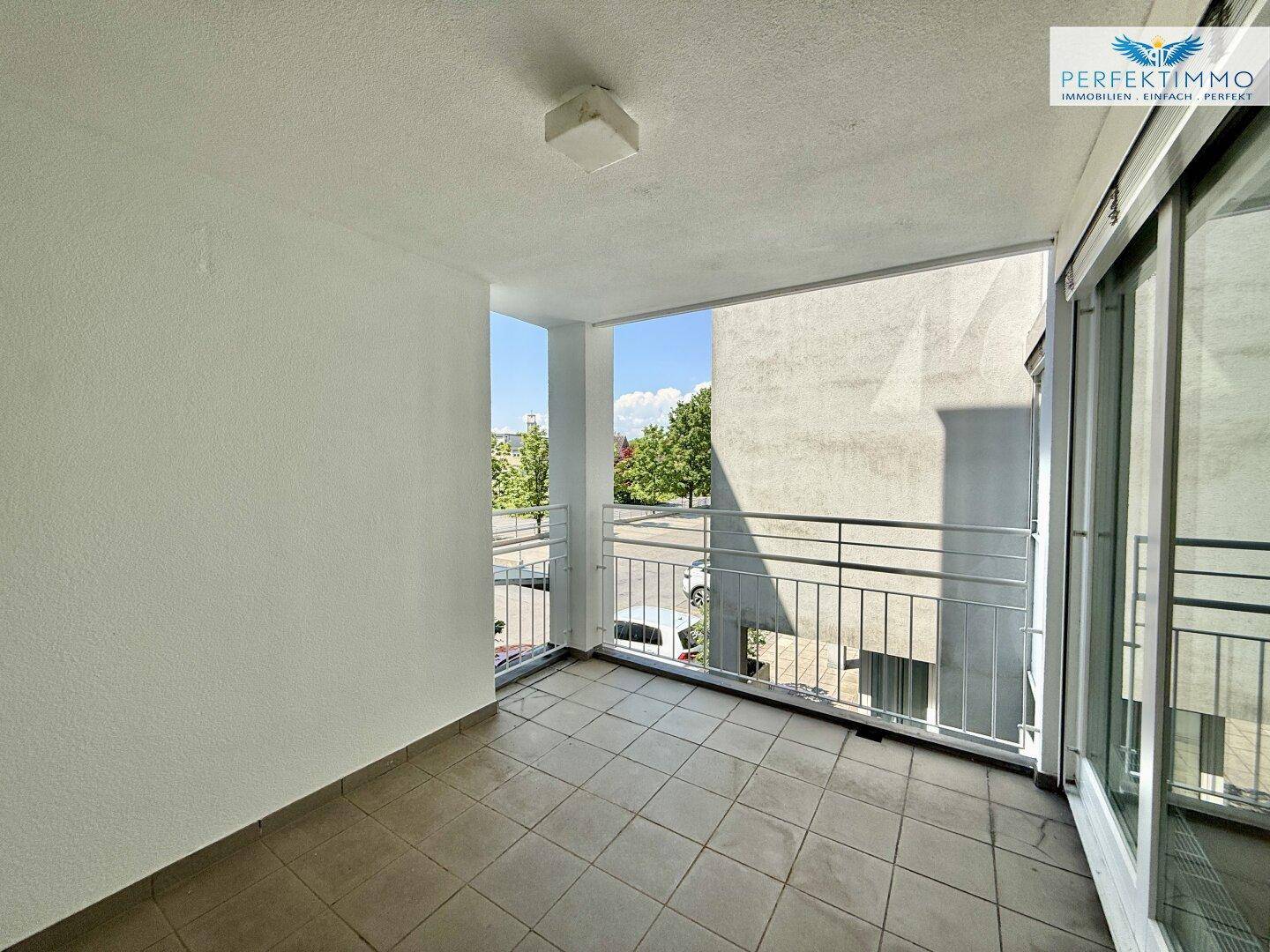 Heller Balkon mit Fliesenboden und Metallgeländer, ideal für entspannte Stunden im Freien.