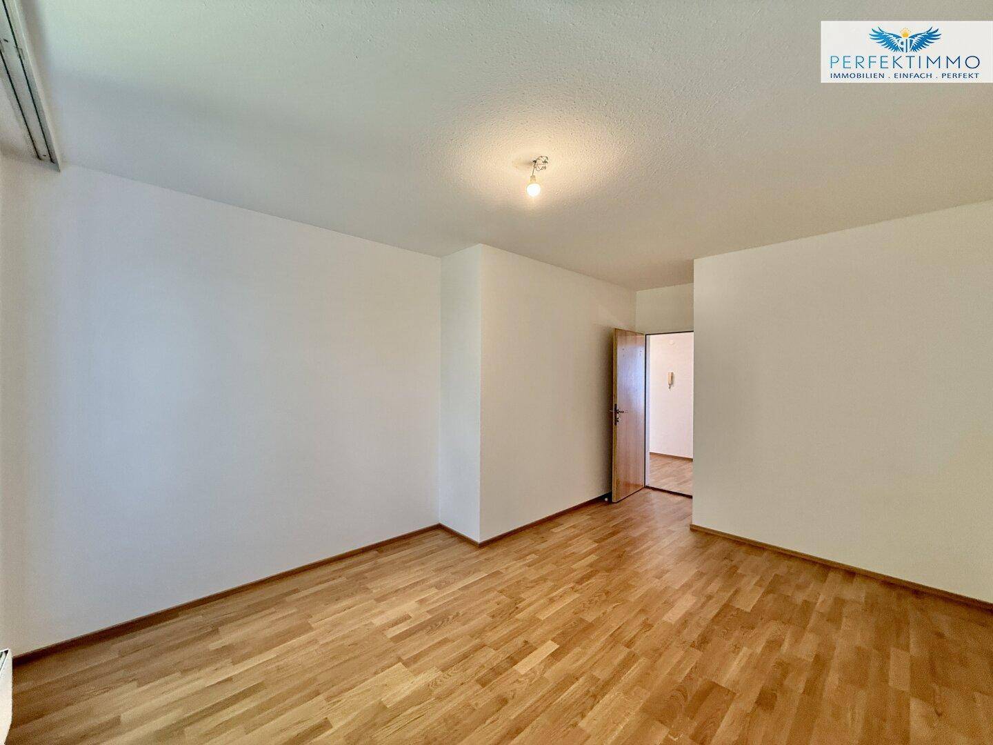 Geräumiges Zimmer mit Parkettboden und Zugang zu einem weiteren Raum, vielseitig nutzbar.
