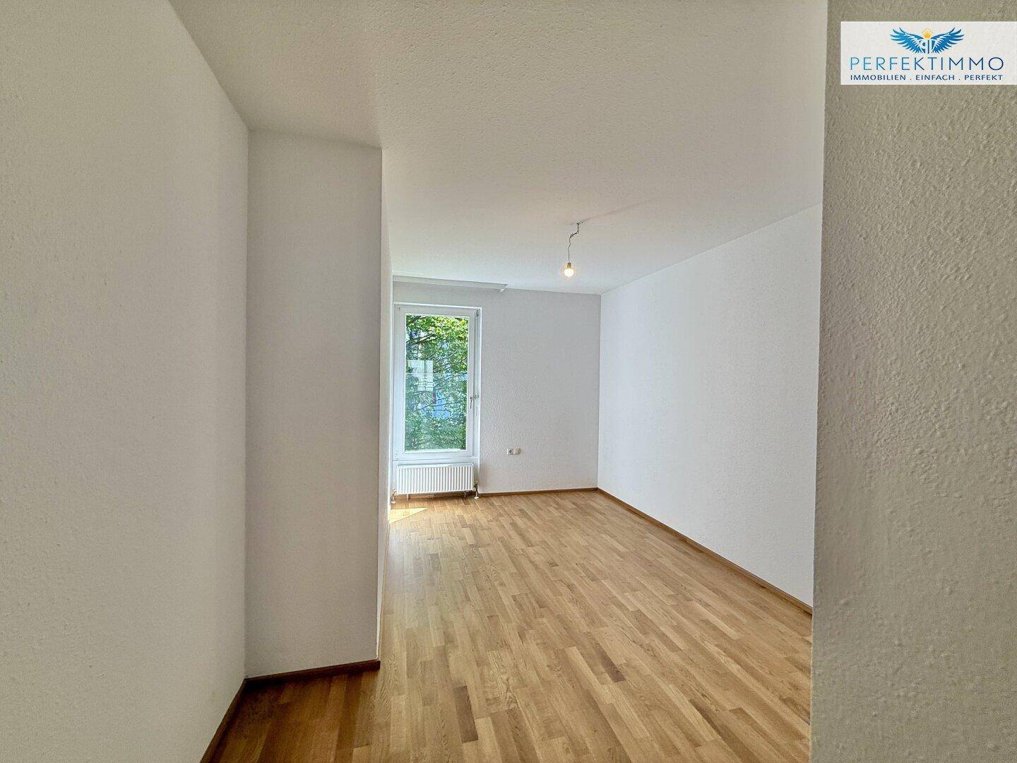 Freundliches Zimmer mit Parkettboden und einem Fenster, das für gute Belichtung sorgt.