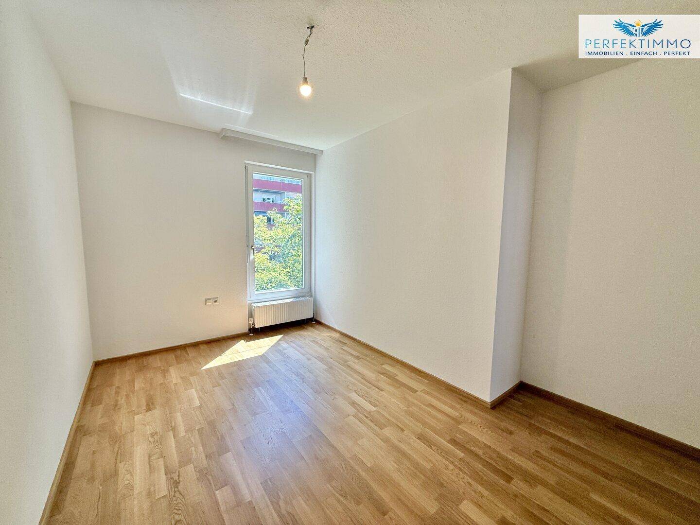 Geräumiges Zimmer mit Parkettboden und Fenster, ideal als Kinder- oder Arbeitszimmer.