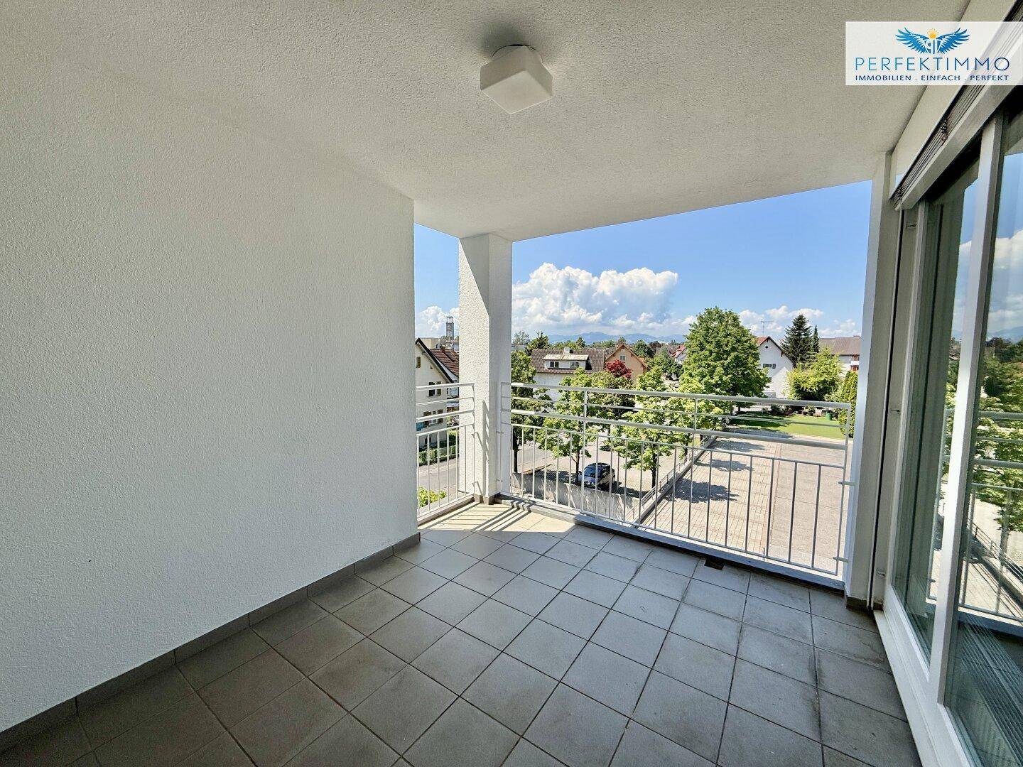 Geräumiger Balkon mit Fliesenboden und Blick auf die grüne Umgebung.