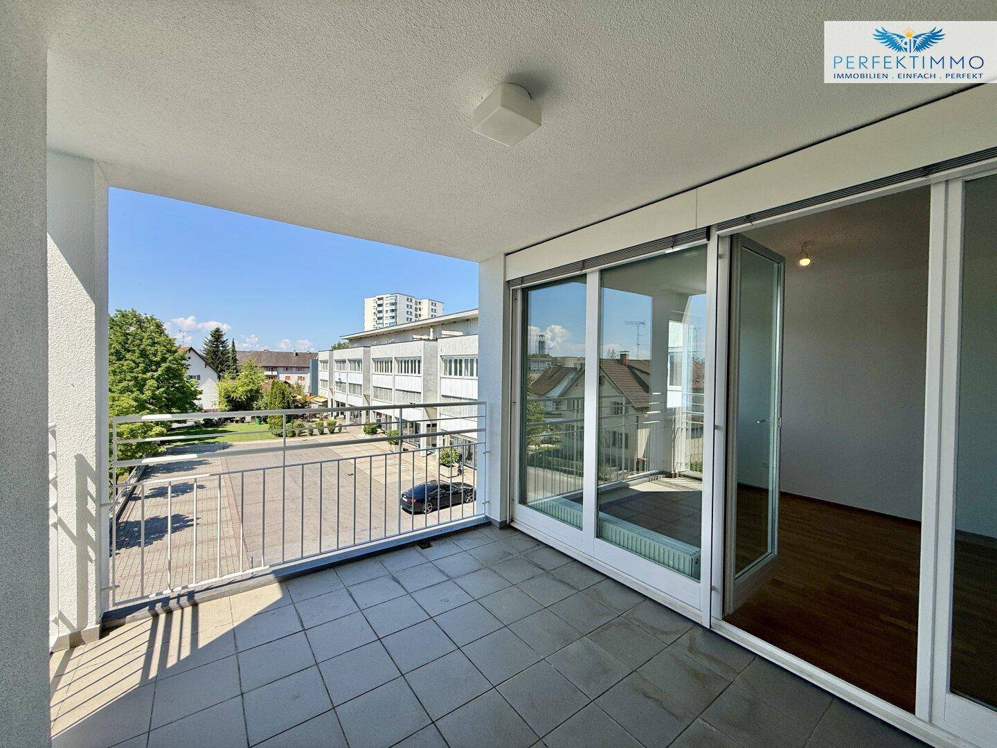 Heller Balkon mit Schiebetüren zum Innenraum und weitem Blick.