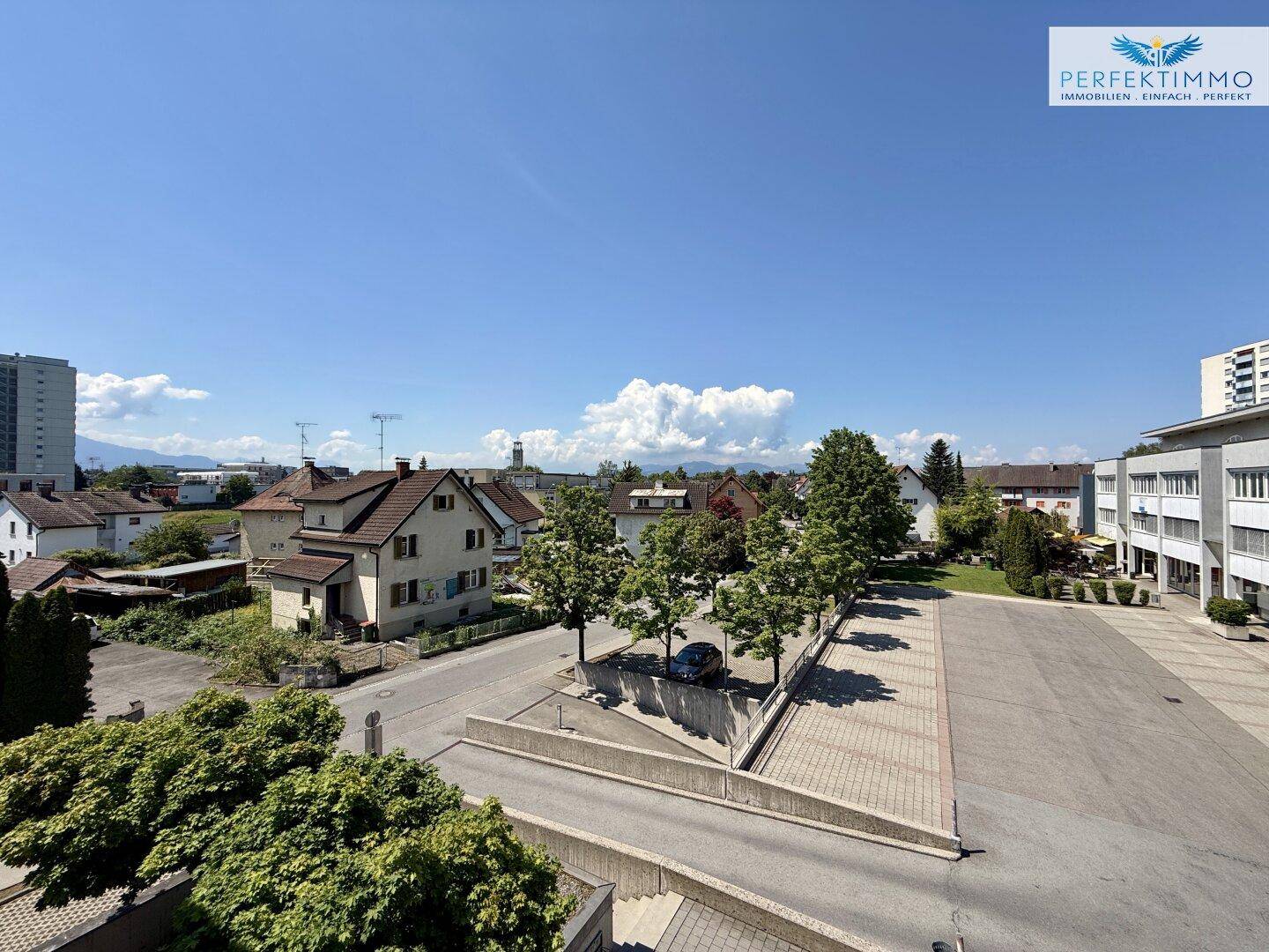 Weitläufiger Blick über die Nachbarschaft mit Bäumen und Bergen im Hintergrund.