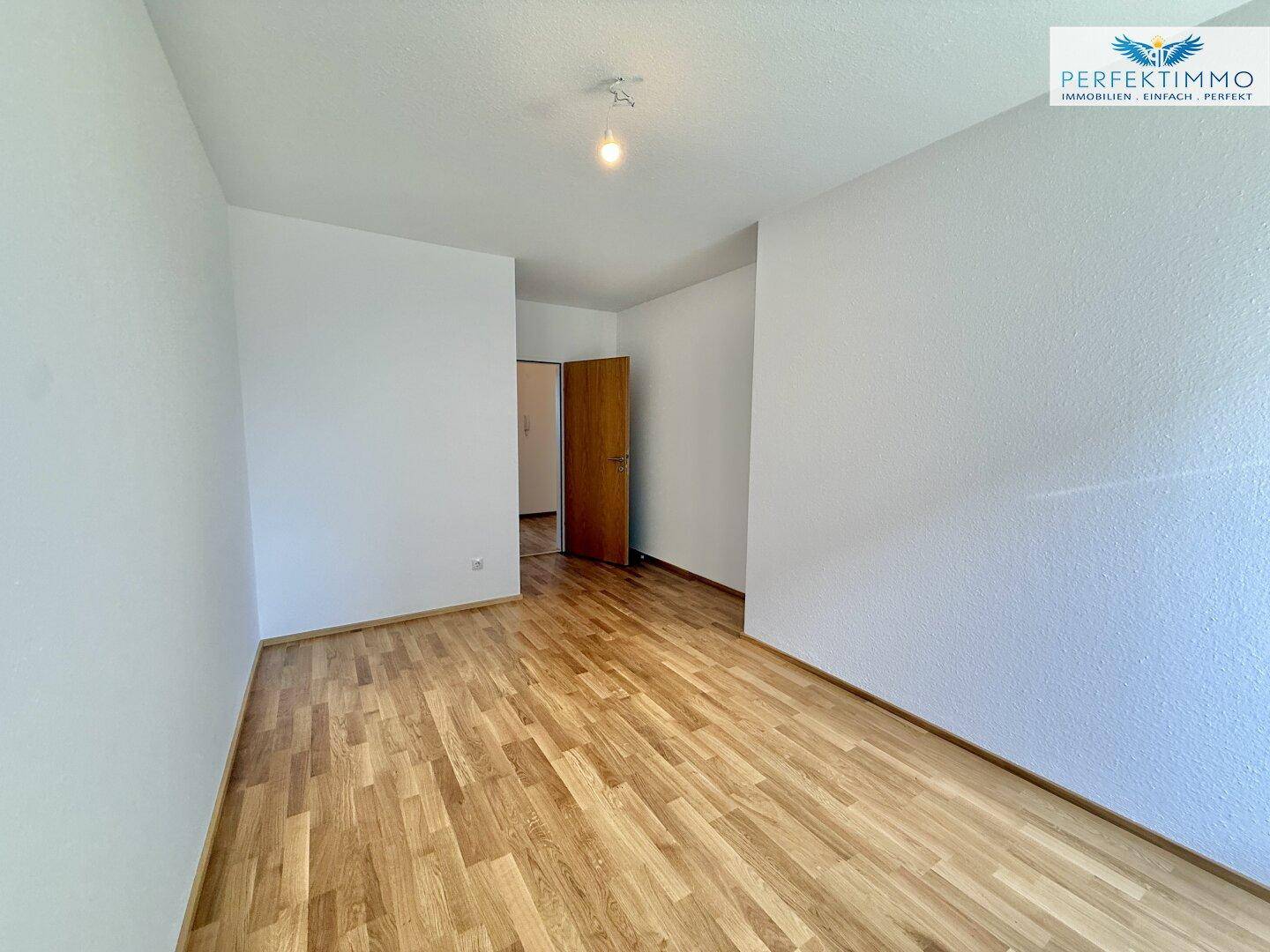 Geräumiges Schlafzimmer mit Parkettboden und Zugang zu anderen Räumen.