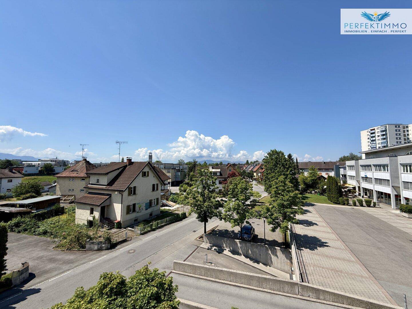 Panoramablick über die Wohngegend mit Häusern, Bäumen und einer weiten Landschaft im Hintergrund.