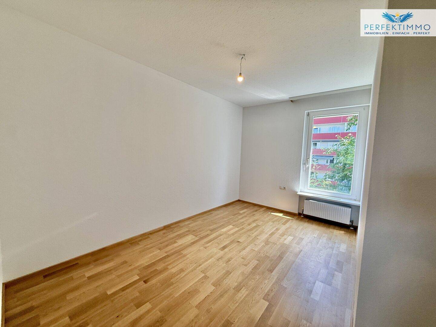 Helles Zimmer mit Parkettboden und weißen Wänden, ideal als Schlaf- oder Arbeitszimmer nutzbar.
