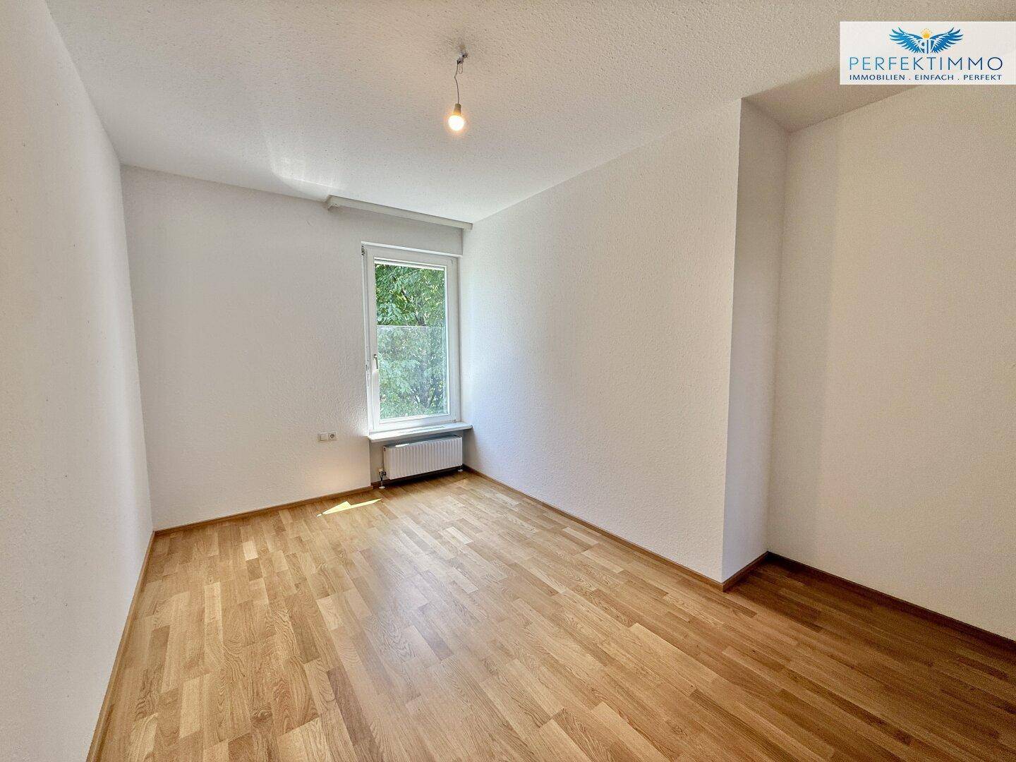 Geräumiges Zimmer mit Parkettboden und weißen Wänden, ideal für vielfältige Nutzungsmöglichkeiten.