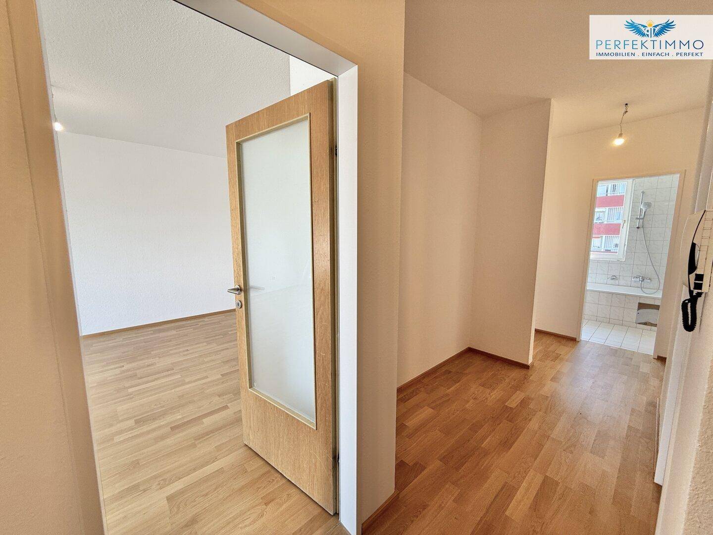 Heller Flur mit Parkettboden und Zugang zu verschiedenen Räumen der Wohnung.