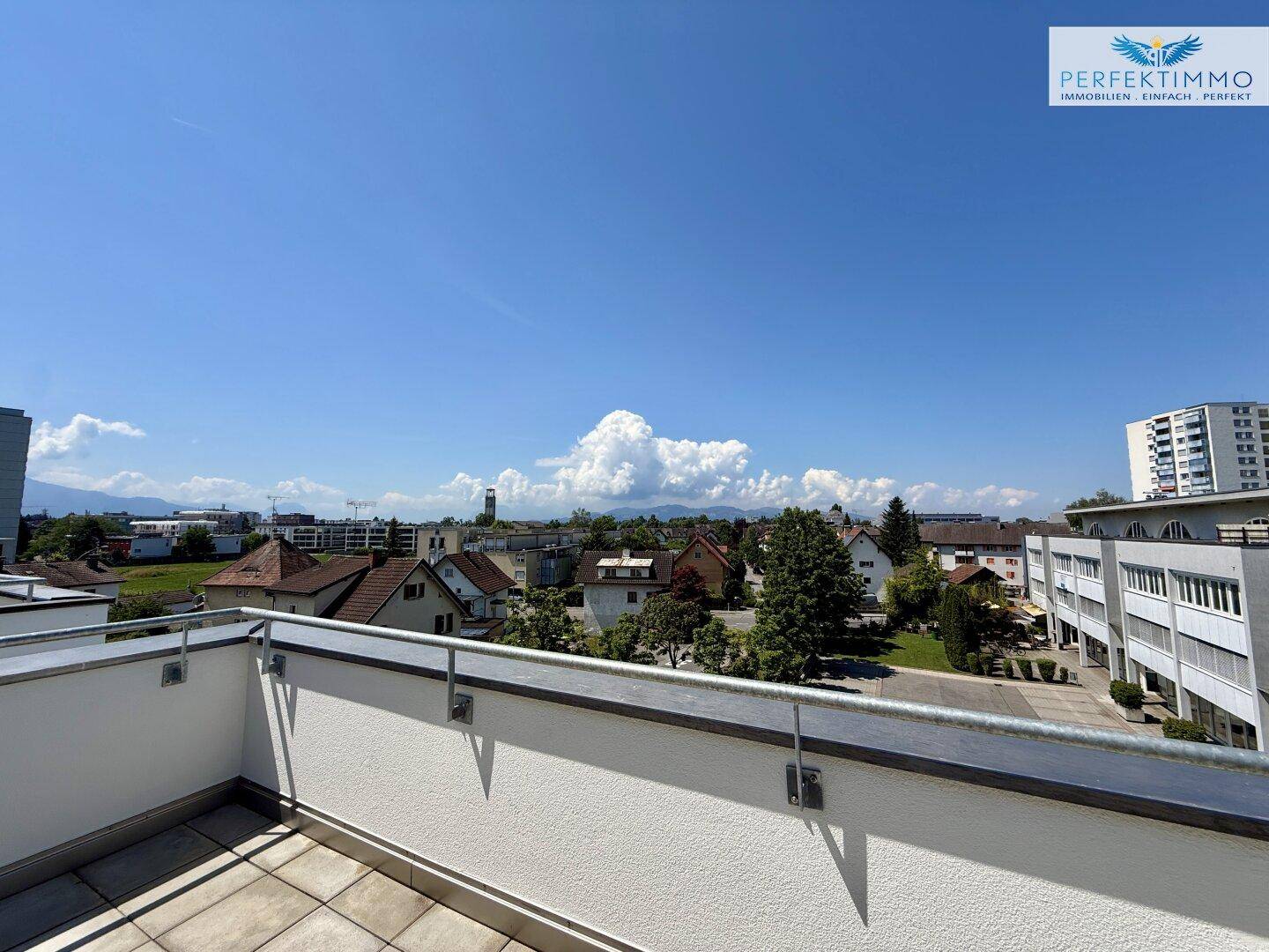 Sonniger Terrassenbereich mit Fliesenboden und weitem Blick über die Nachbarschaft.
