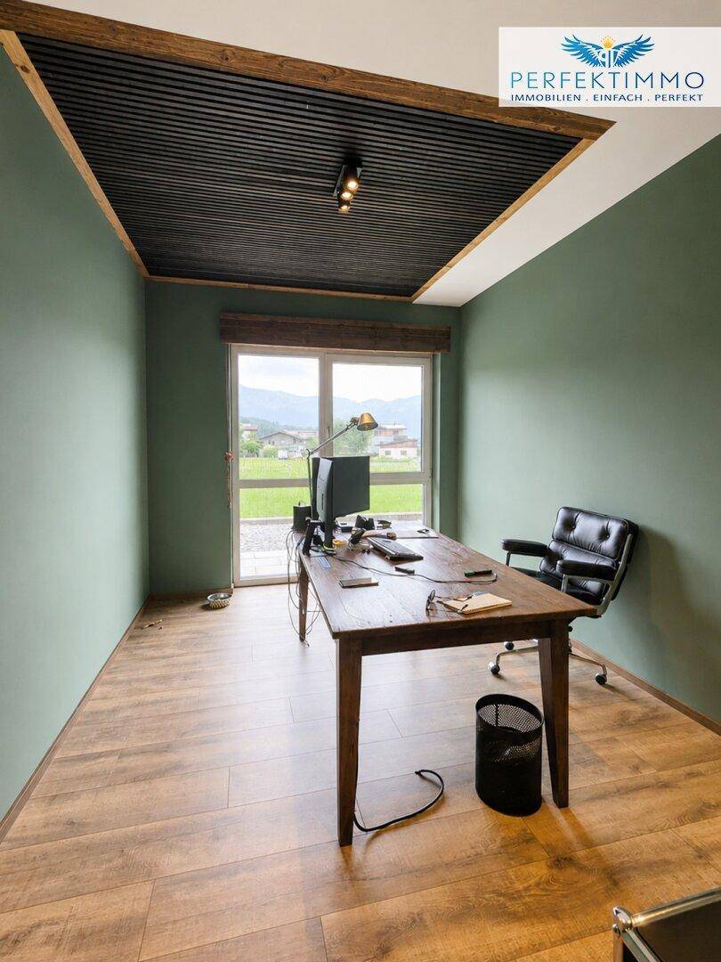 Einzelbüro mit Holztisch, Bürostuhl und Fenster mit Blick auf die Landschaft.