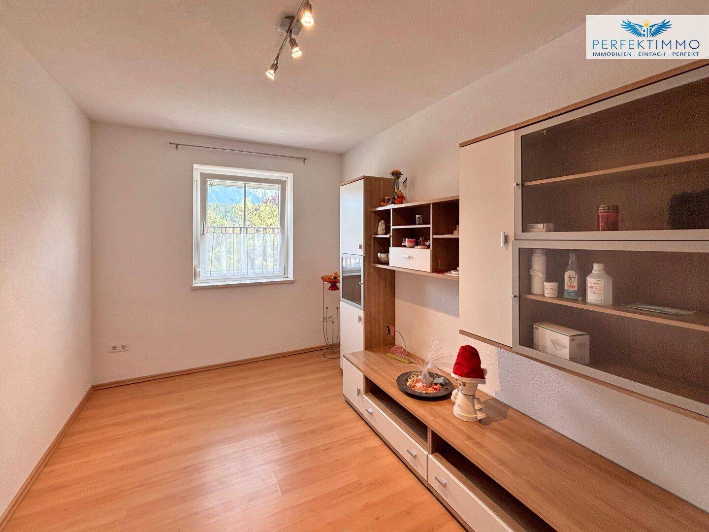 Helles Zimmer mit Holzboden und praktischen Einbauschränken, ideal als Gäste- oder Arbeitszimmer.