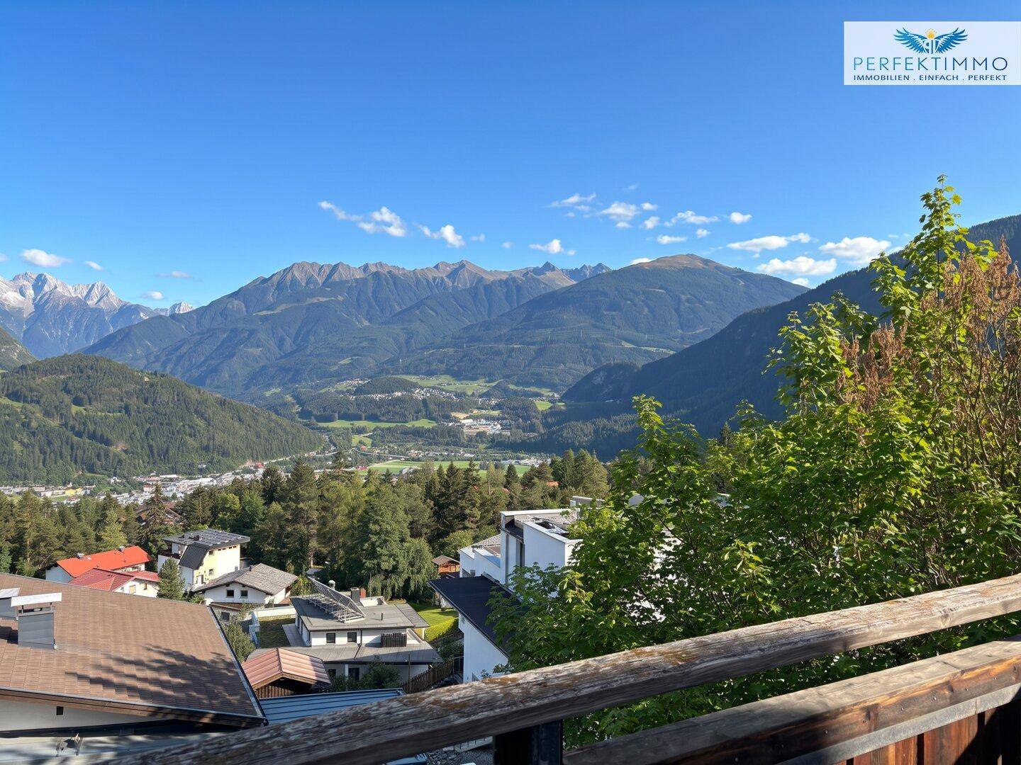 Weitläufiger Ausblick vom Balkon auf die beeindruckende Berglandschaft und grüne Täler.