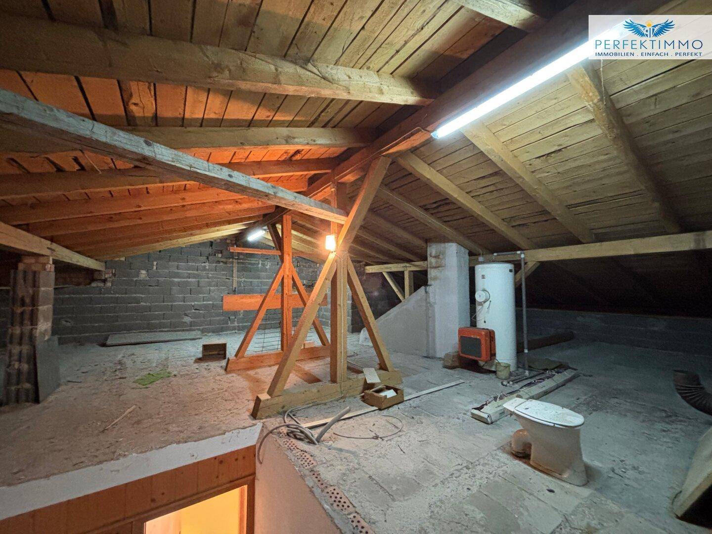 Unausgebauter Dachboden mit sichtbaren Holzbalken, bietet Potenzial für zukünftige Erweiterungen.
