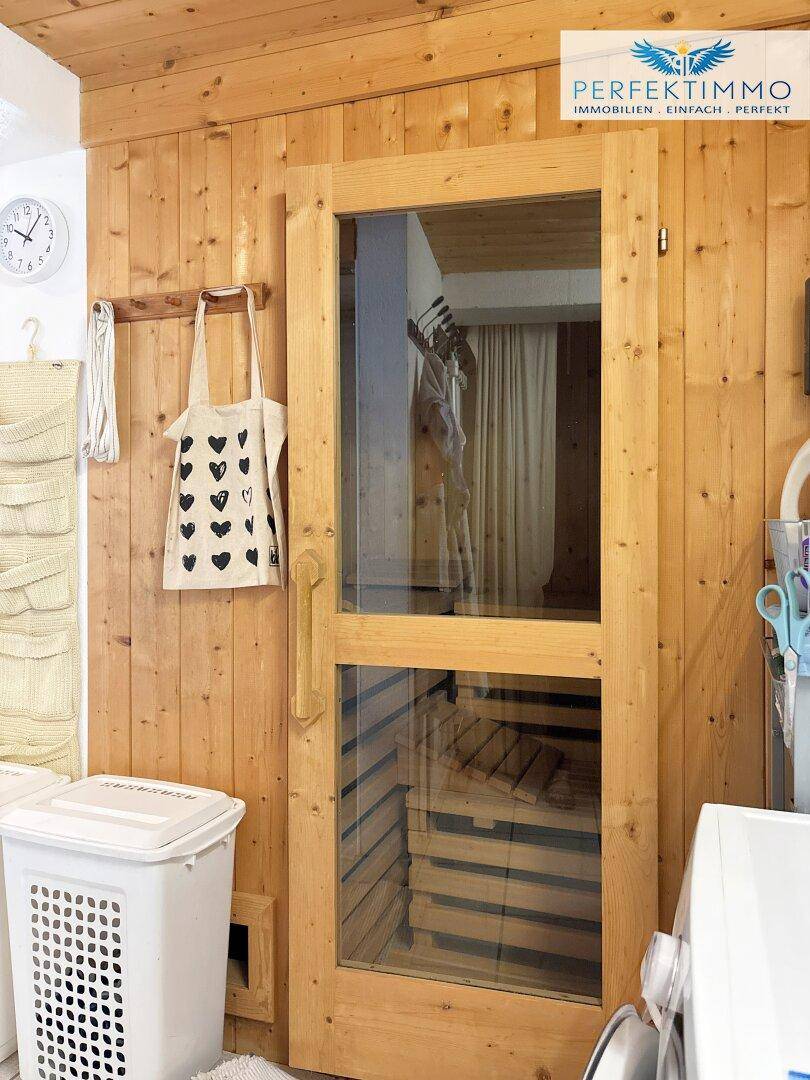 Hauswirtschaftsraum mit Waschmaschine und einer integrierten Holzsauna für Wellness.