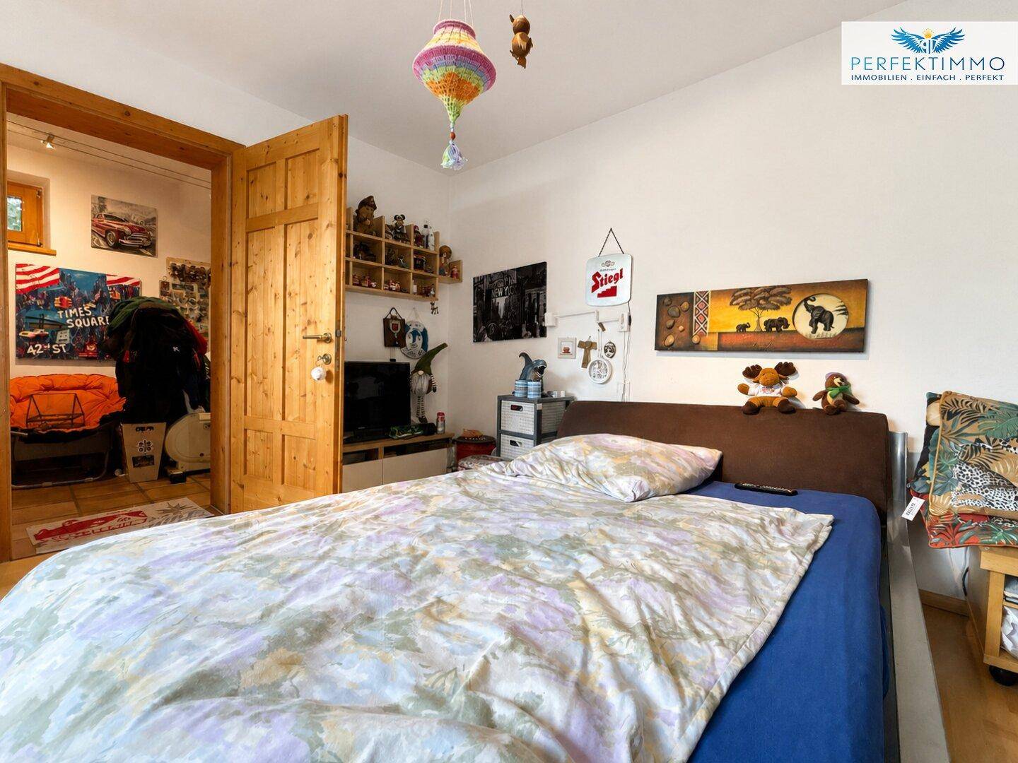 Kinderzimmer mit Einzelbett, Spielzeug und bunten Dekorationen, hell und freundlich.
