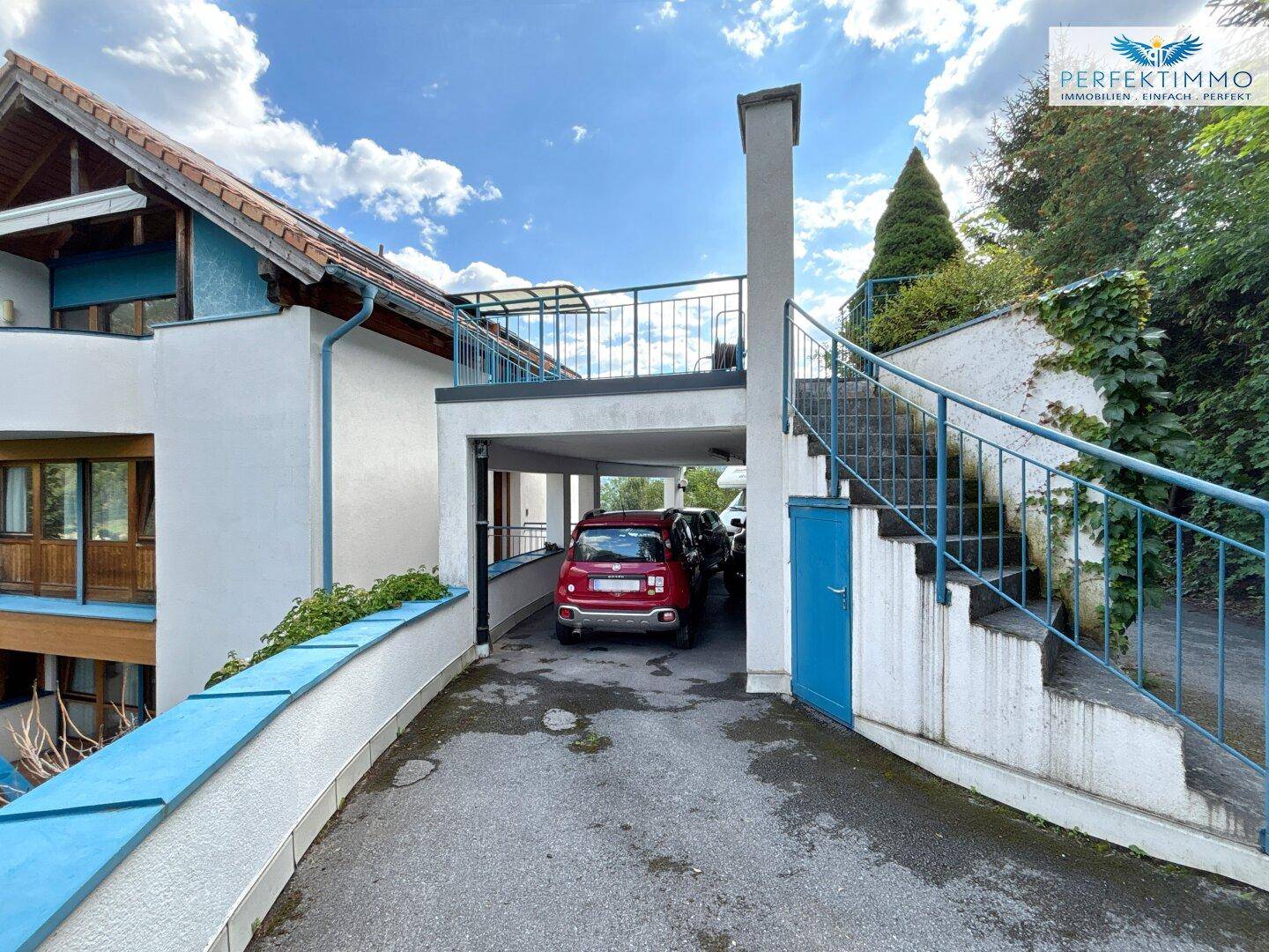 Außenansicht des Hauses mit überdachtem Parkplatz und Außentreppe zum oberen Bereich.