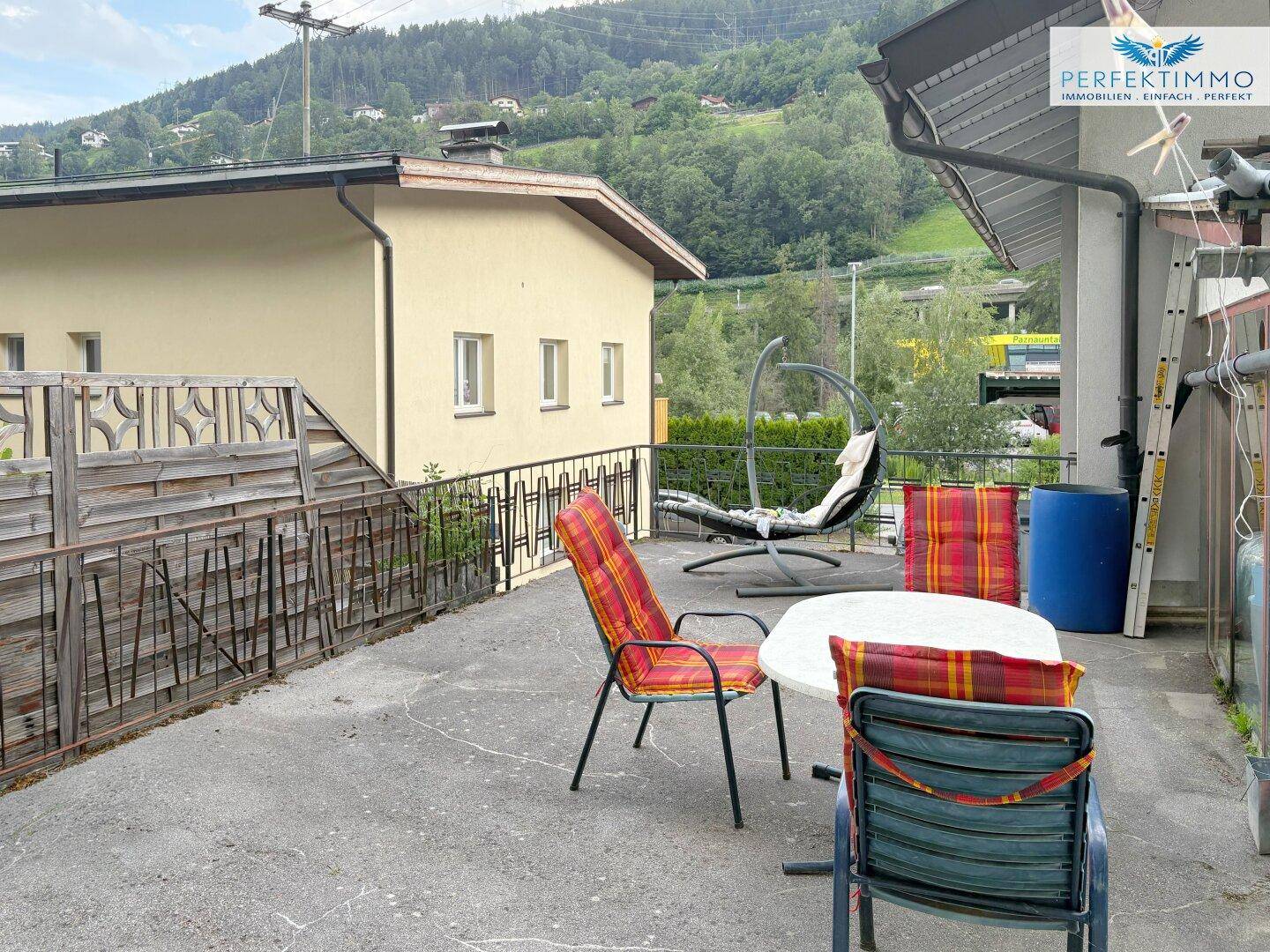 Große Terrasse mit Sitzgelegenheiten und Blick auf die umliegenden Berge.