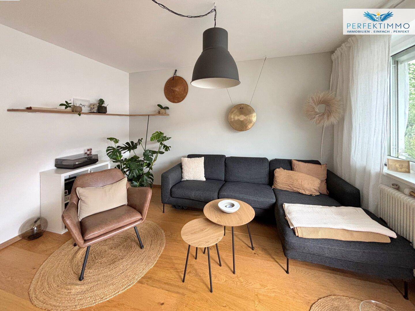Gemütliches Wohnzimmer mit Holzboden, bequemer Sitzecke und stilvoller Dekoration.