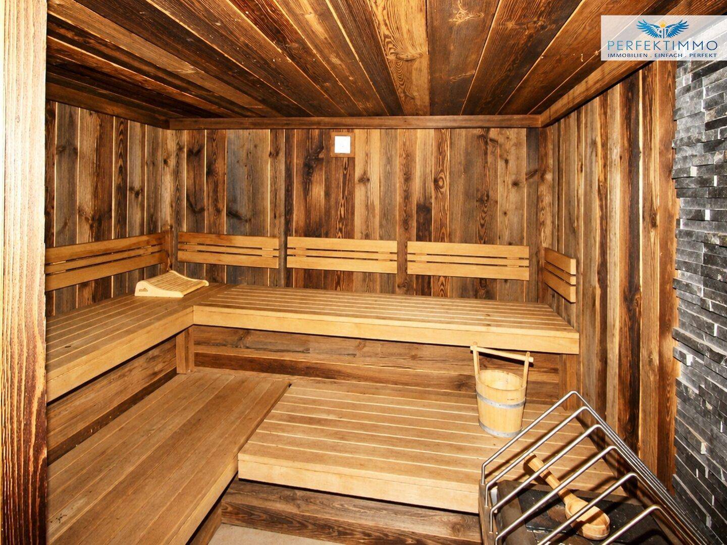 Traditionelle Holzsauna mit mehreren Bänken und einem Saunaofen für Entspannung.