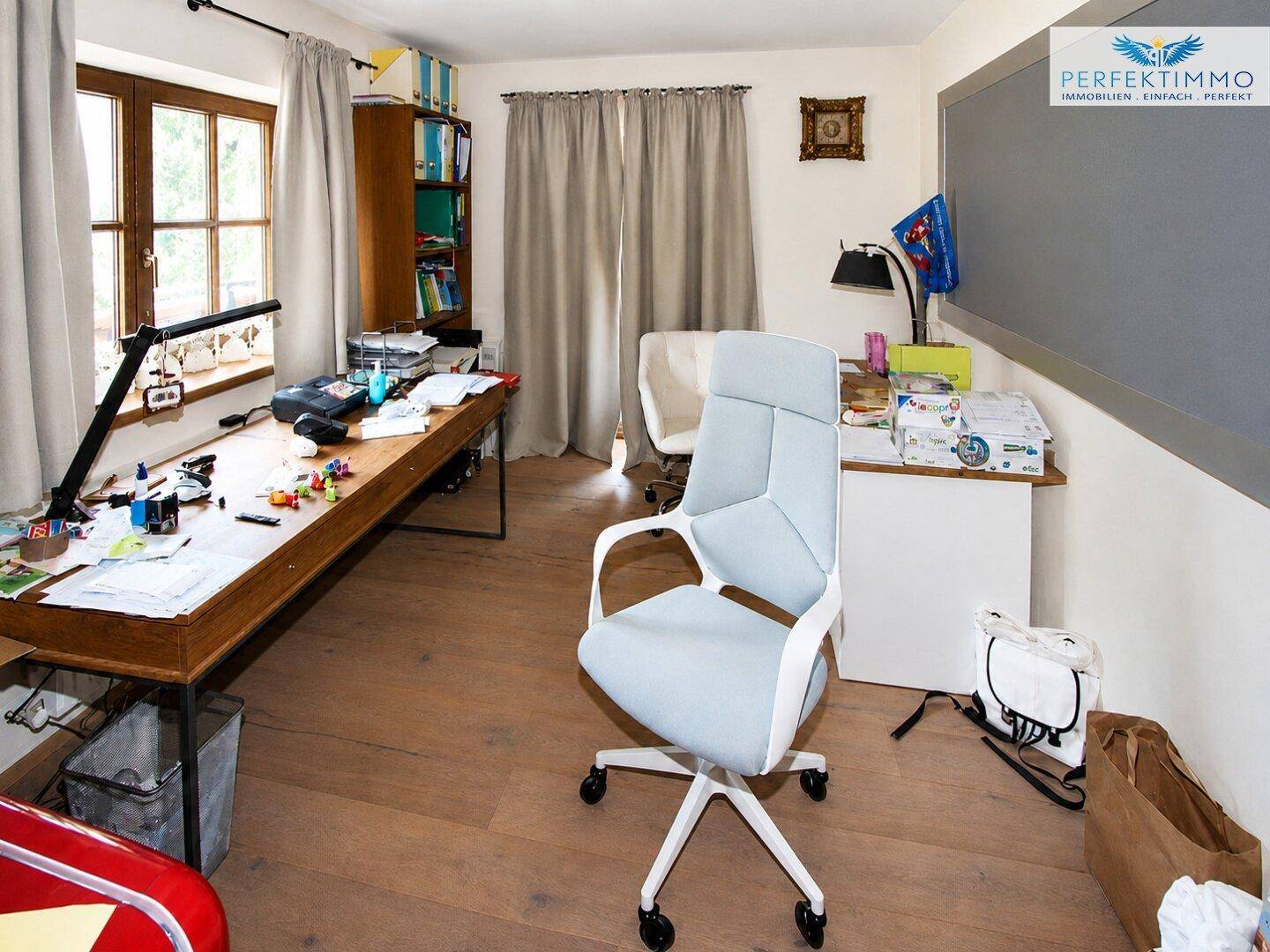 Helles Arbeitszimmer mit großem Schreibtisch, Bürostuhl und Holzfußboden.
