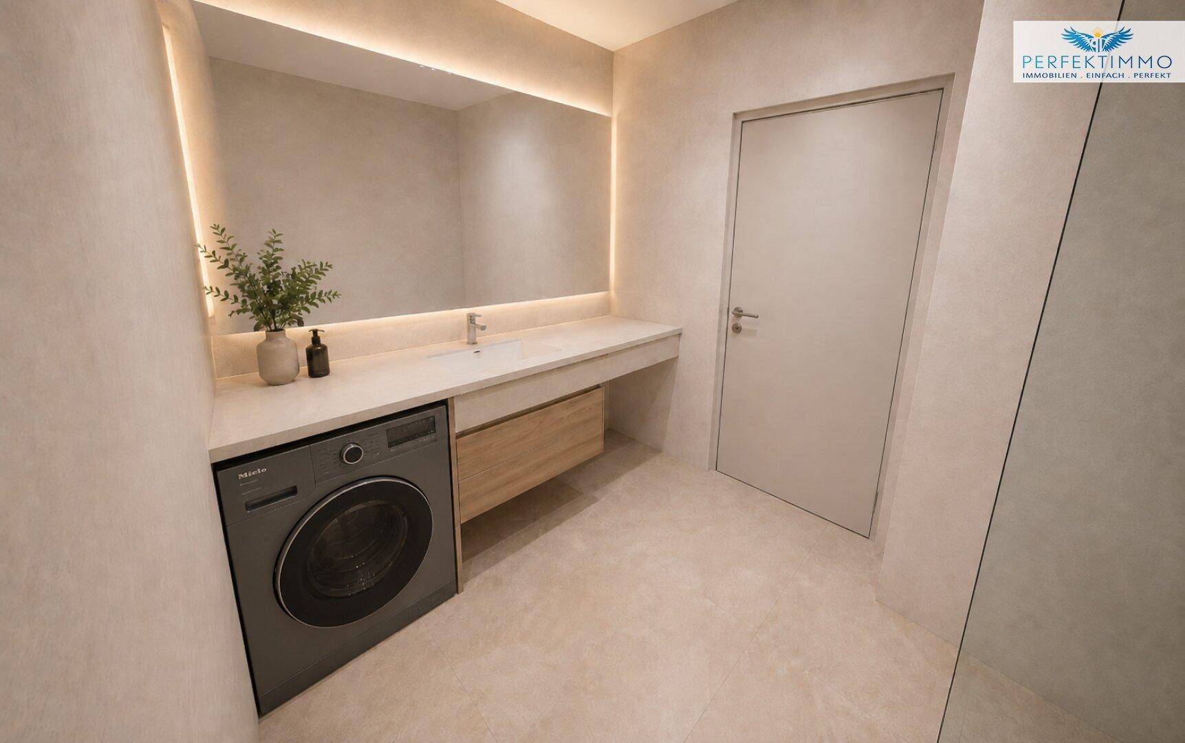 Helles Badezimmer mit modernem Waschtisch, großem Spiegel und integrierter Waschmaschine.