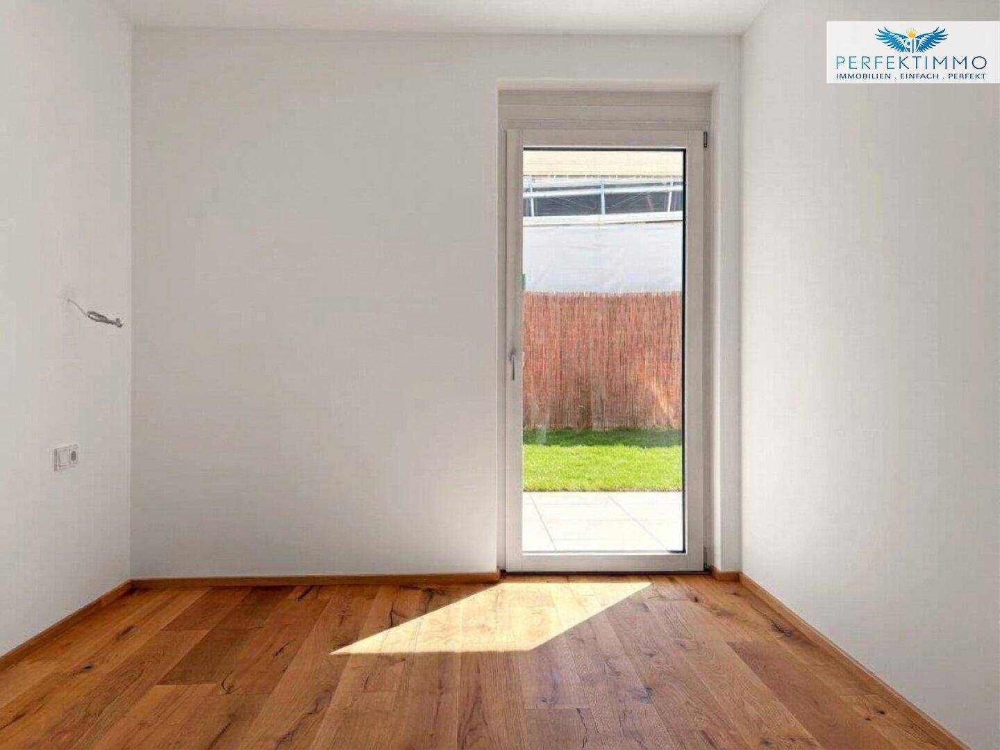 Gemütliches Zimmer mit Holzboden und direktem Zugang zum Garten, ideal als Schlafzimmer.