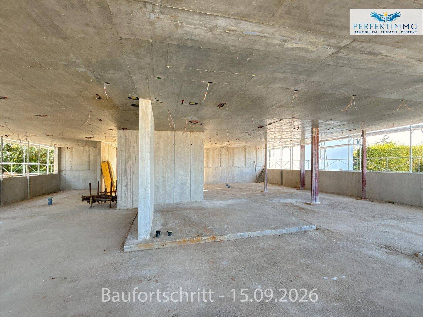 Geräumiger Rohbau-Innenraum mit tragenden Betonsäulen und Wänden, bereit für den weiteren Ausbau.