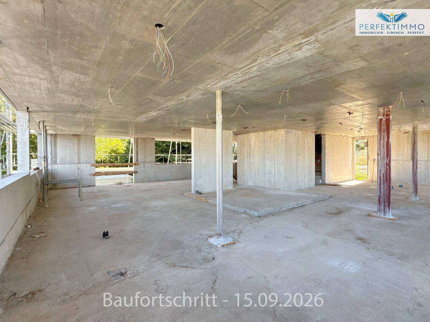 Weitläufiger Rohbau-Innenraum mit Betonsäulen und großen Fensterbereichen, die viel Helligkeit versprechen.