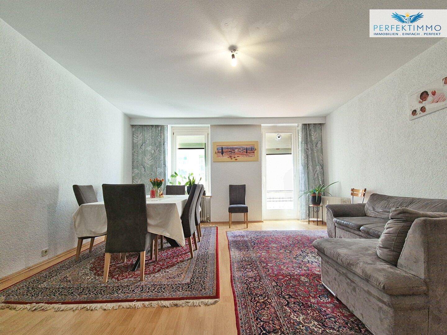 Geräumiger Wohn- und Essbereich mit Sofa, Esstisch und Parkettboden.