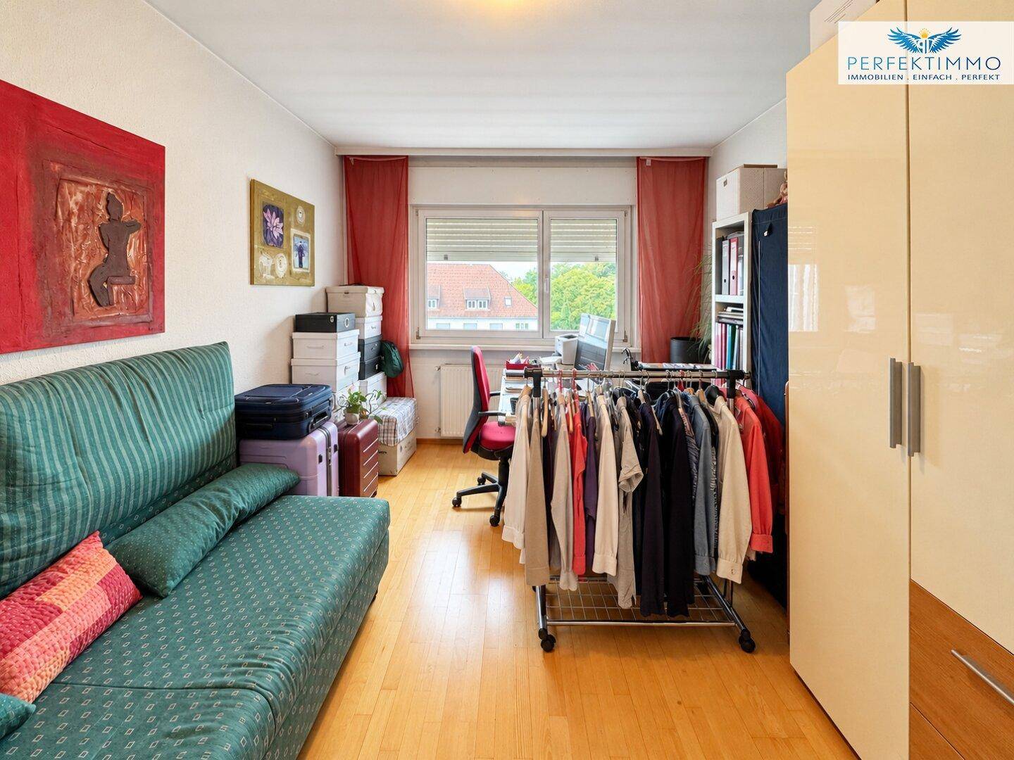 Helles Zimmer mit Parkettboden, Schlafsofa und Schrank, ideal als Gäste- oder Arbeitszimmer.