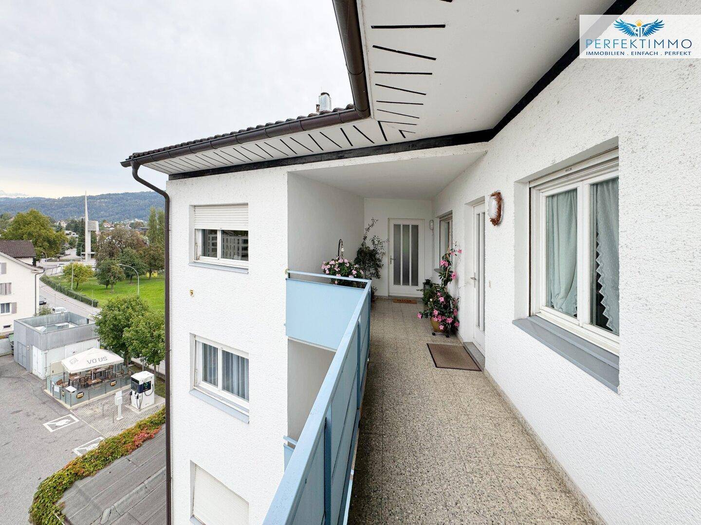 Langer Balkon entlang der Fassade mit Blick auf die Umgebung und die Straße.