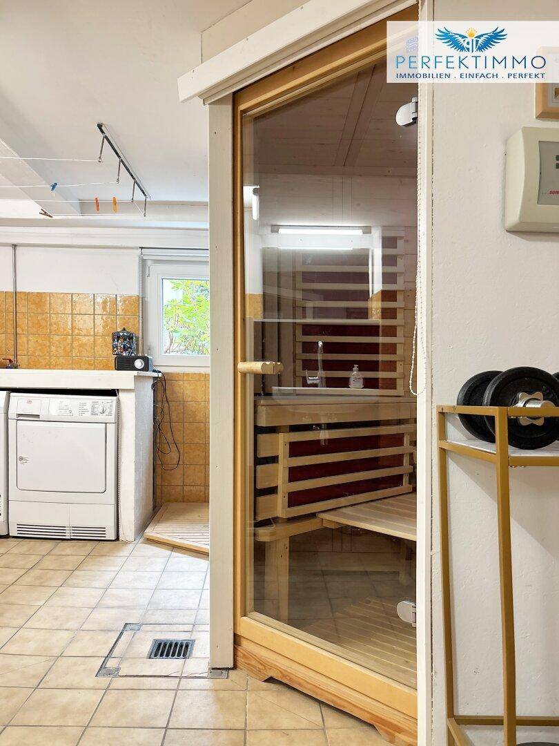 Hauswirtschaftsraum mit Waschmaschine, Trockner und einer integrierten Sauna.