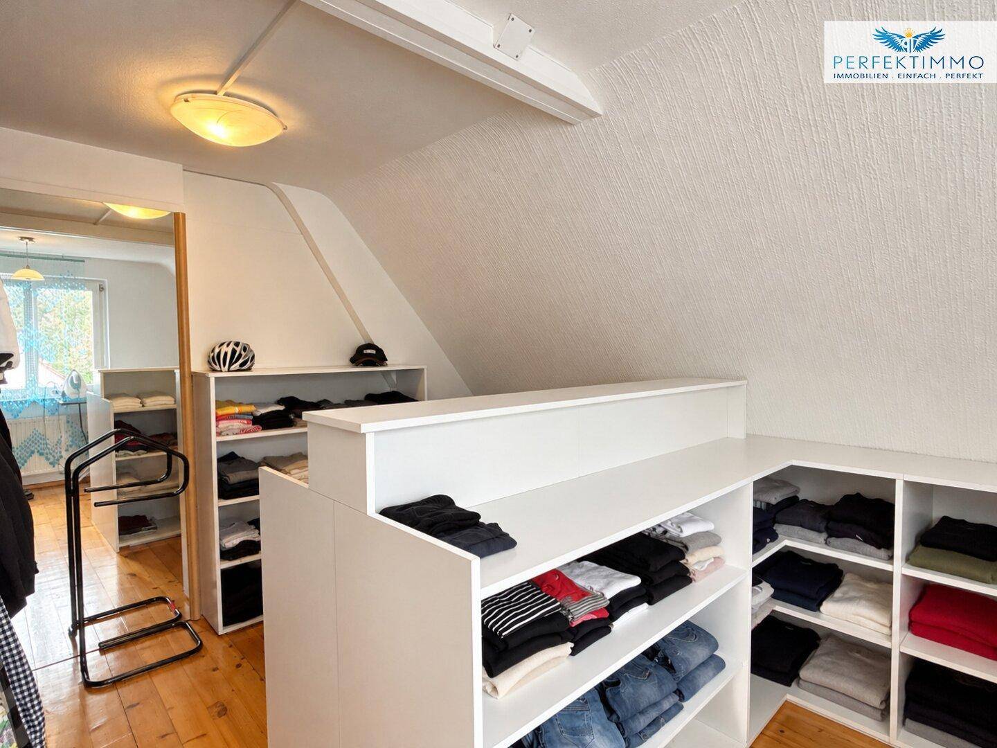 Praktischer begehbarer Kleiderschrank mit offenen Regalen für Kleidung und Accessoires.