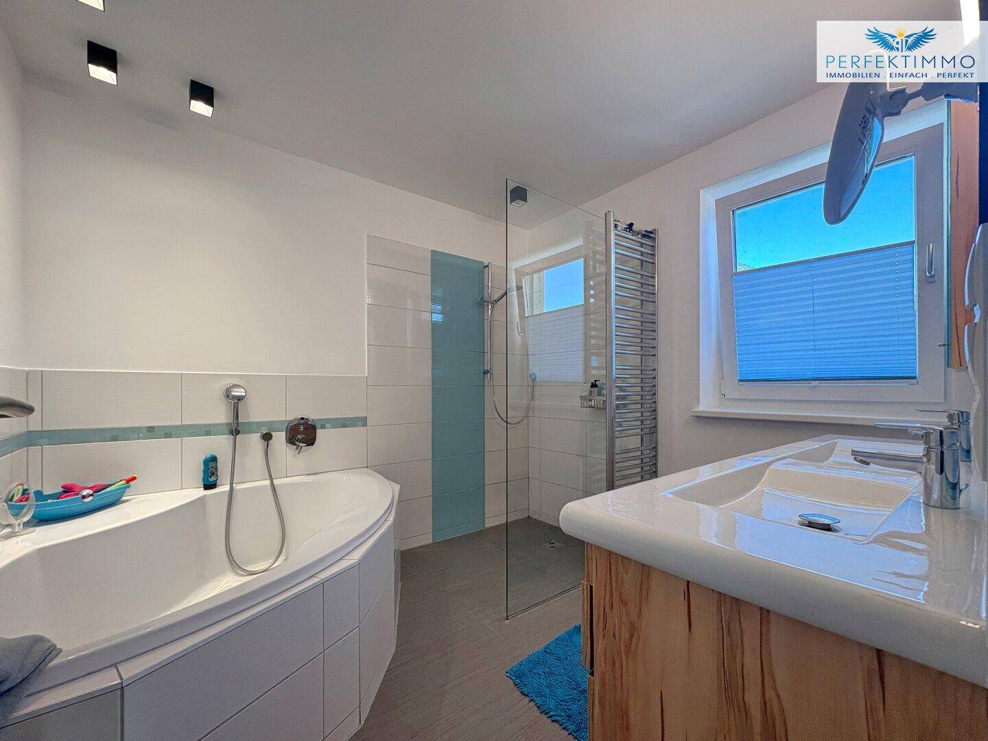 Modernes Badezimmer mit Eckbadewanne, Dusche und Doppelwaschbecken.