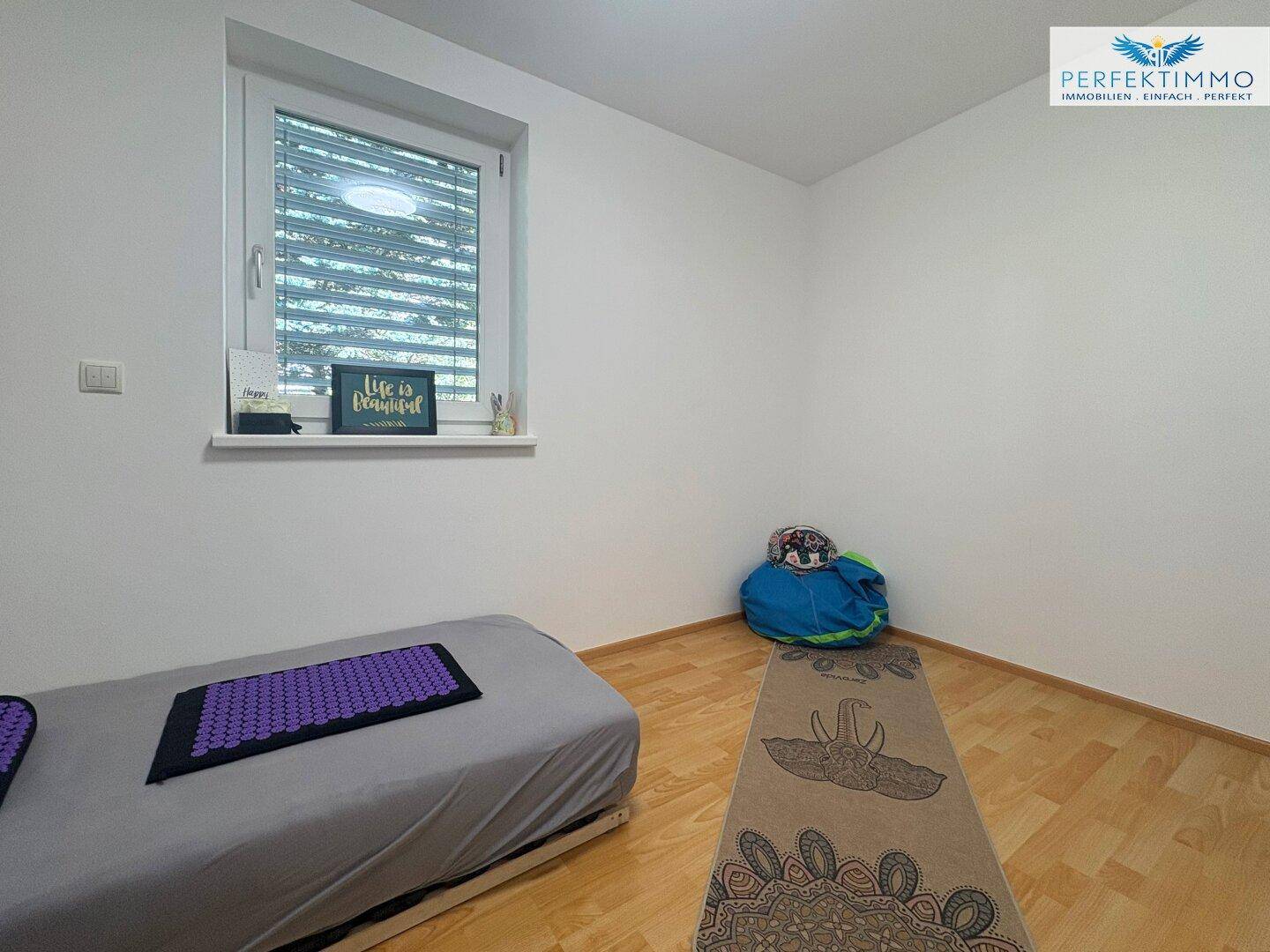 Helles Zimmer mit Holzboden und Fenster, ideal als Gäste- oder Arbeitszimmer.