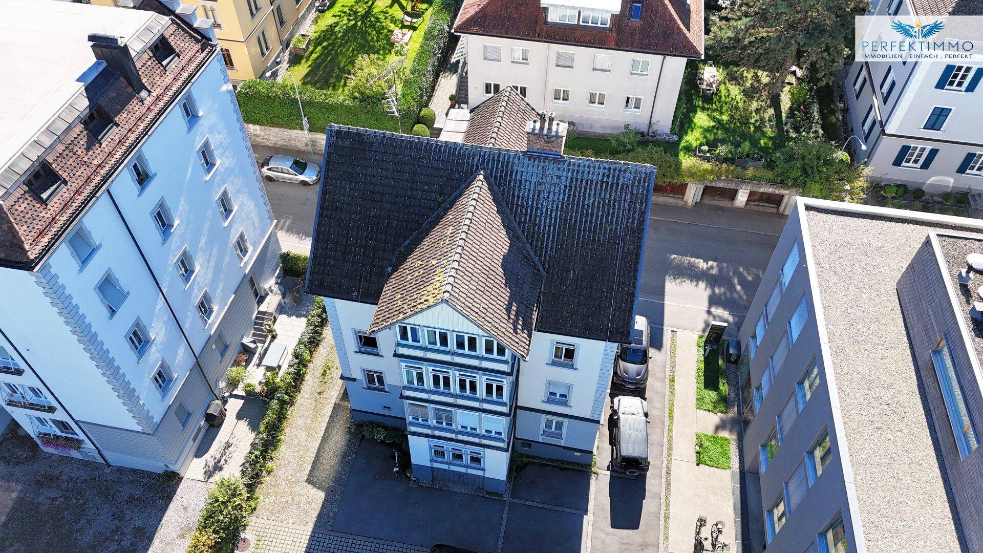 Detaillierte Luftansicht des Gebäudes mit Dachstruktur und angrenzenden modernen Wohnkomplexen.