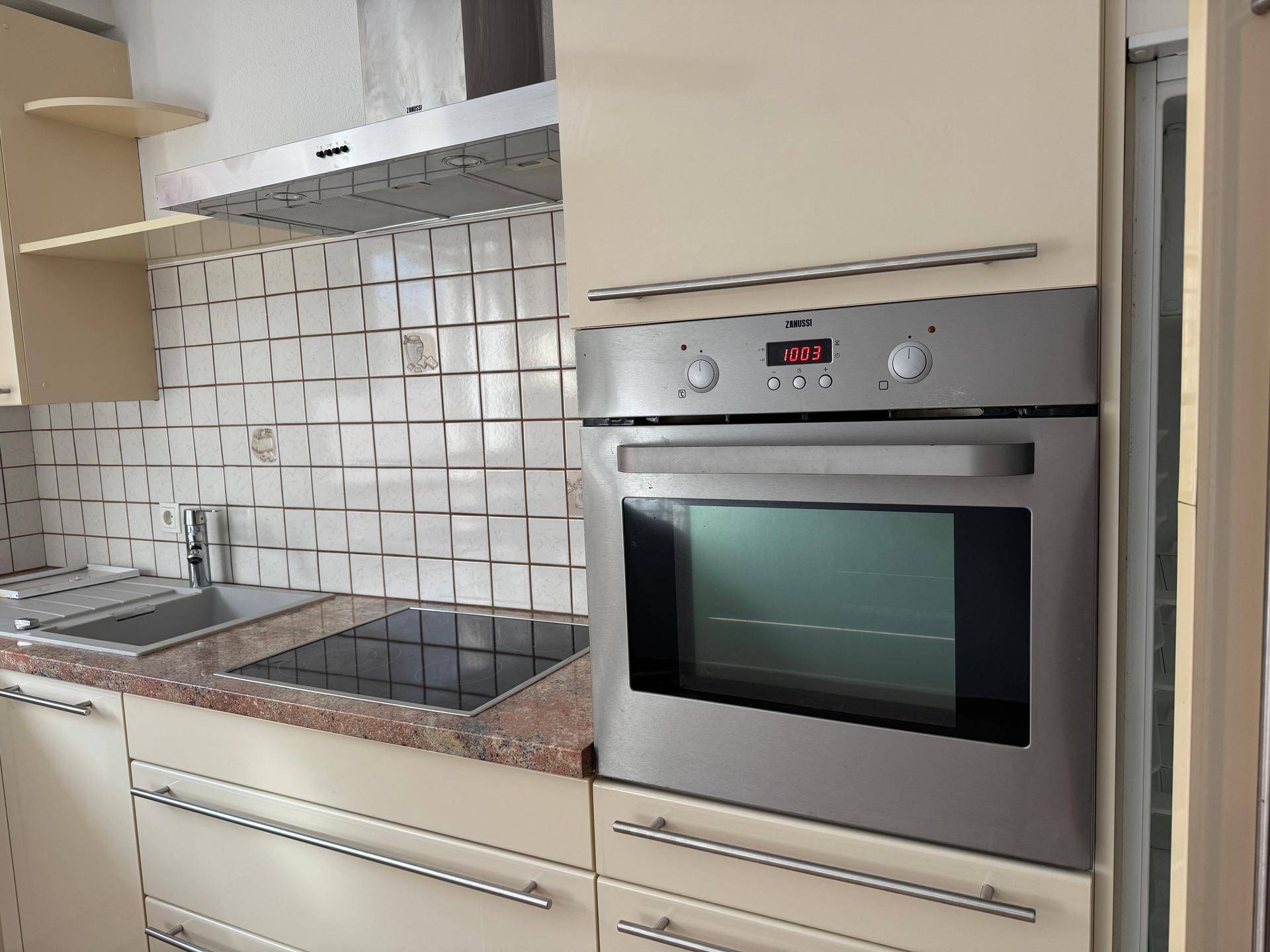 Detailansicht der Küche mit integriertem Backofen und Induktionskochfeld.